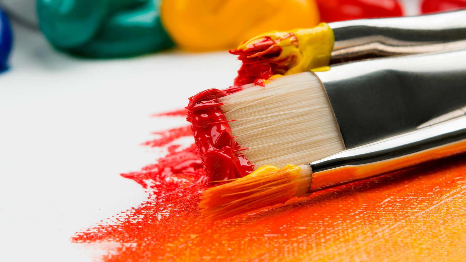 three silver paint brushes on white textile