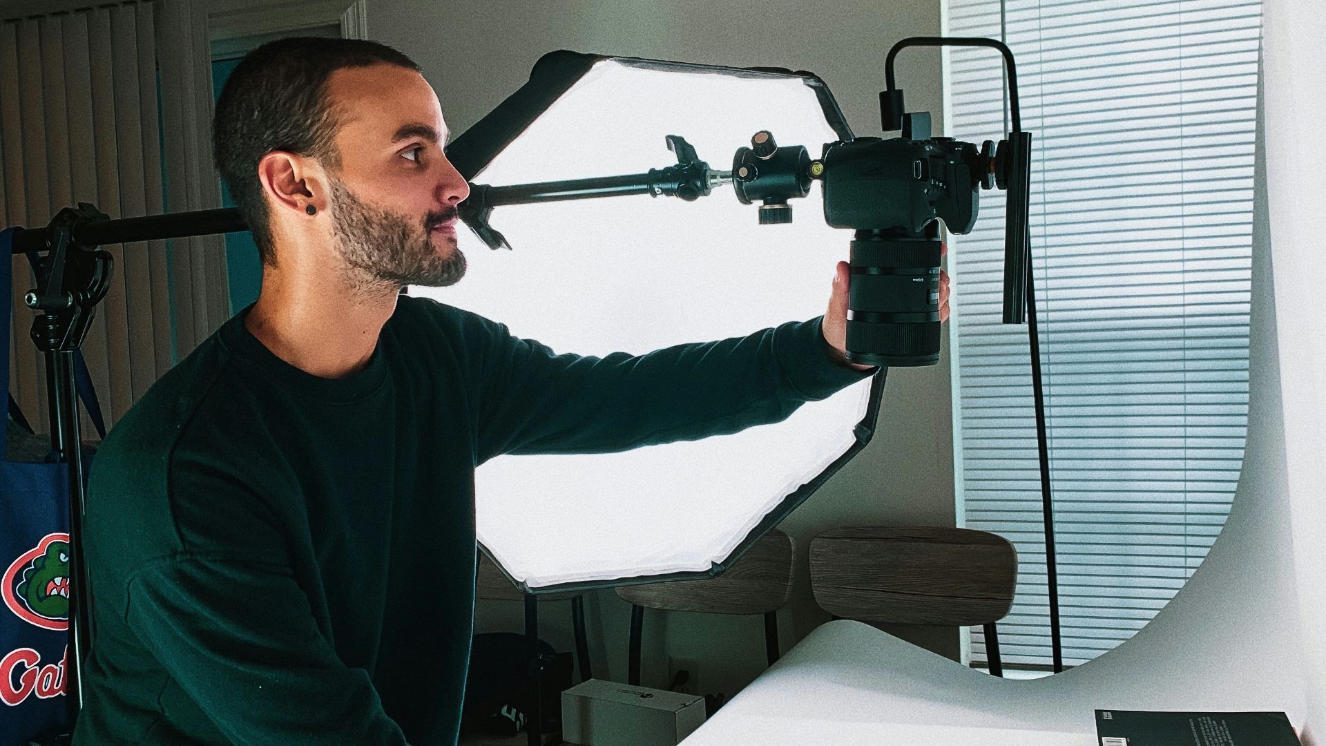 man in green sweater holding black and red power tool