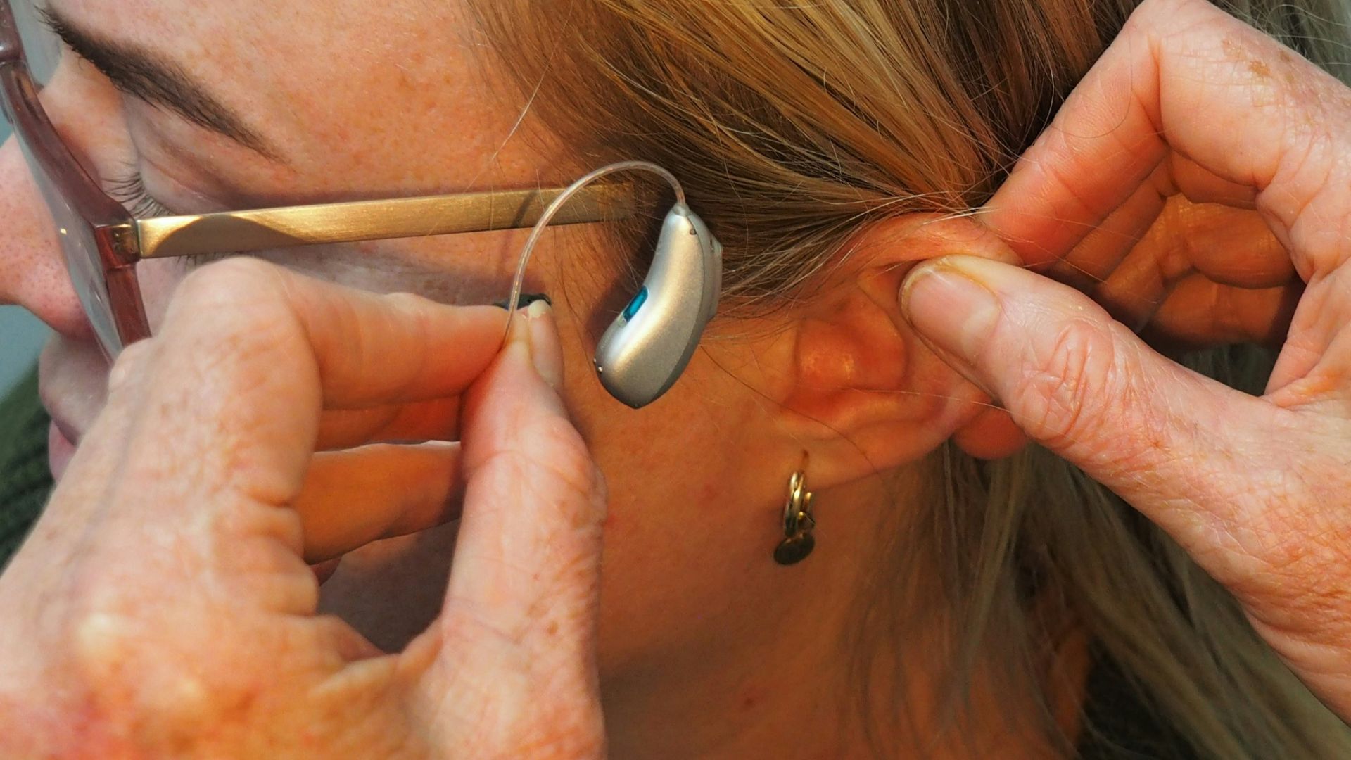 a woman is putting on a pair of glasses