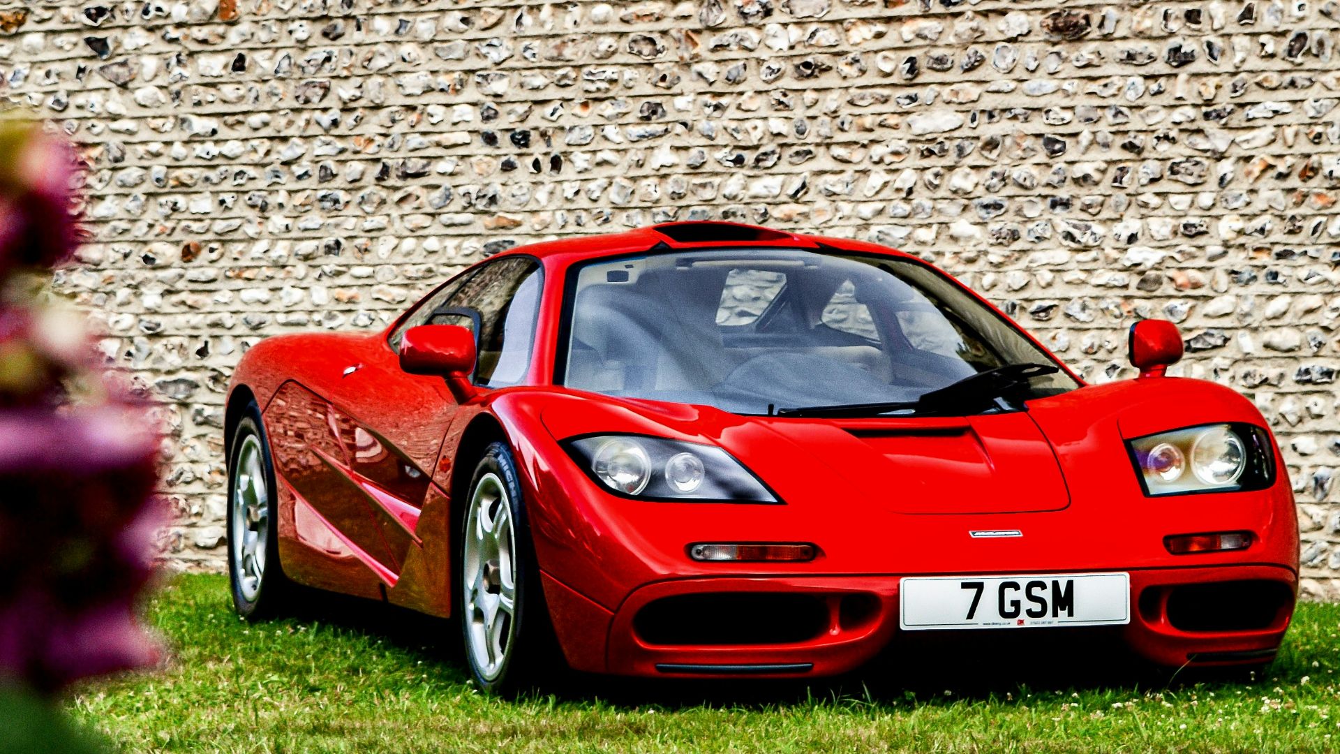 red porsche 911 parked on green grass field during daytime