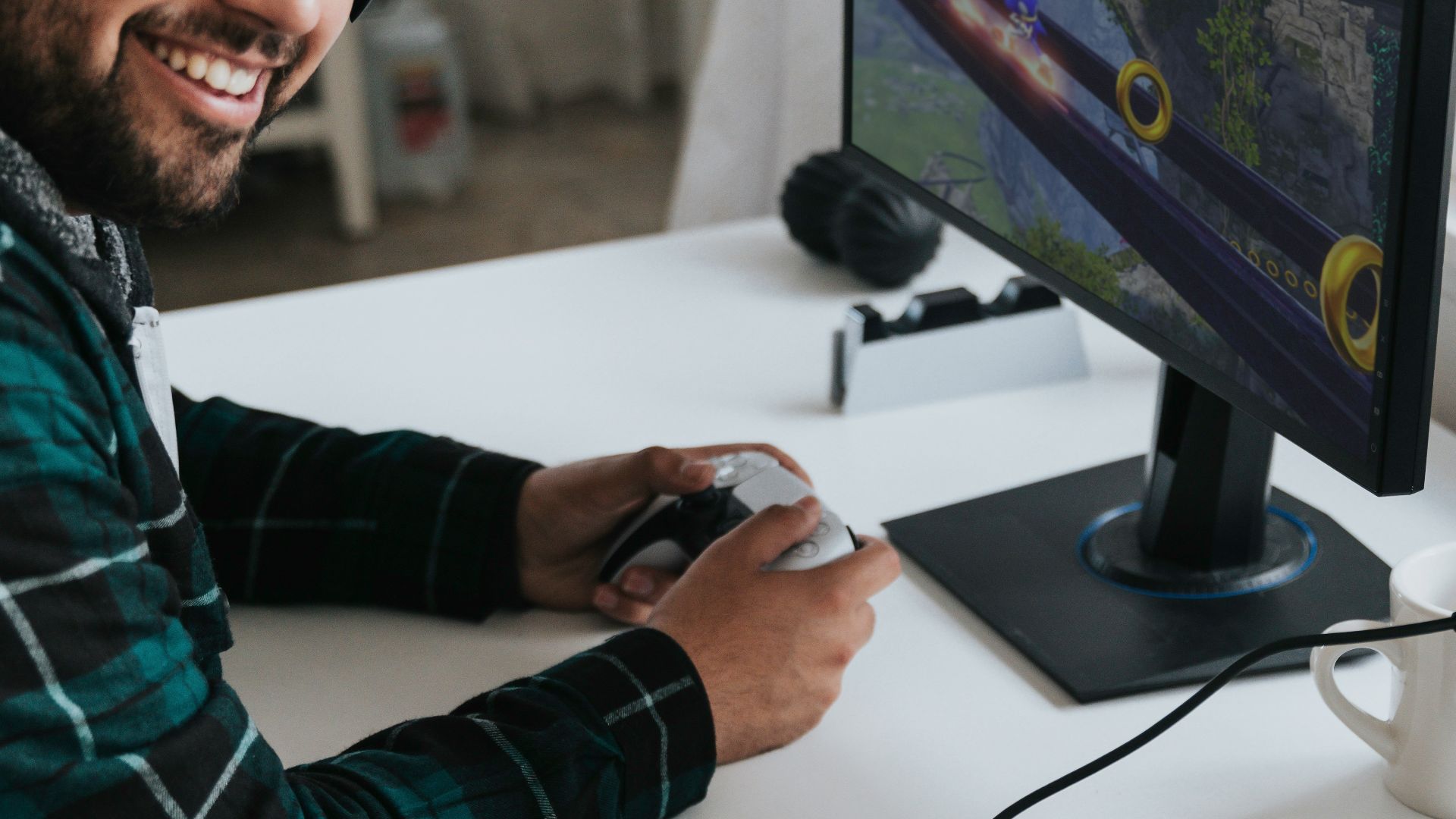 a man wearing headphones and sitting at a desk with a computer