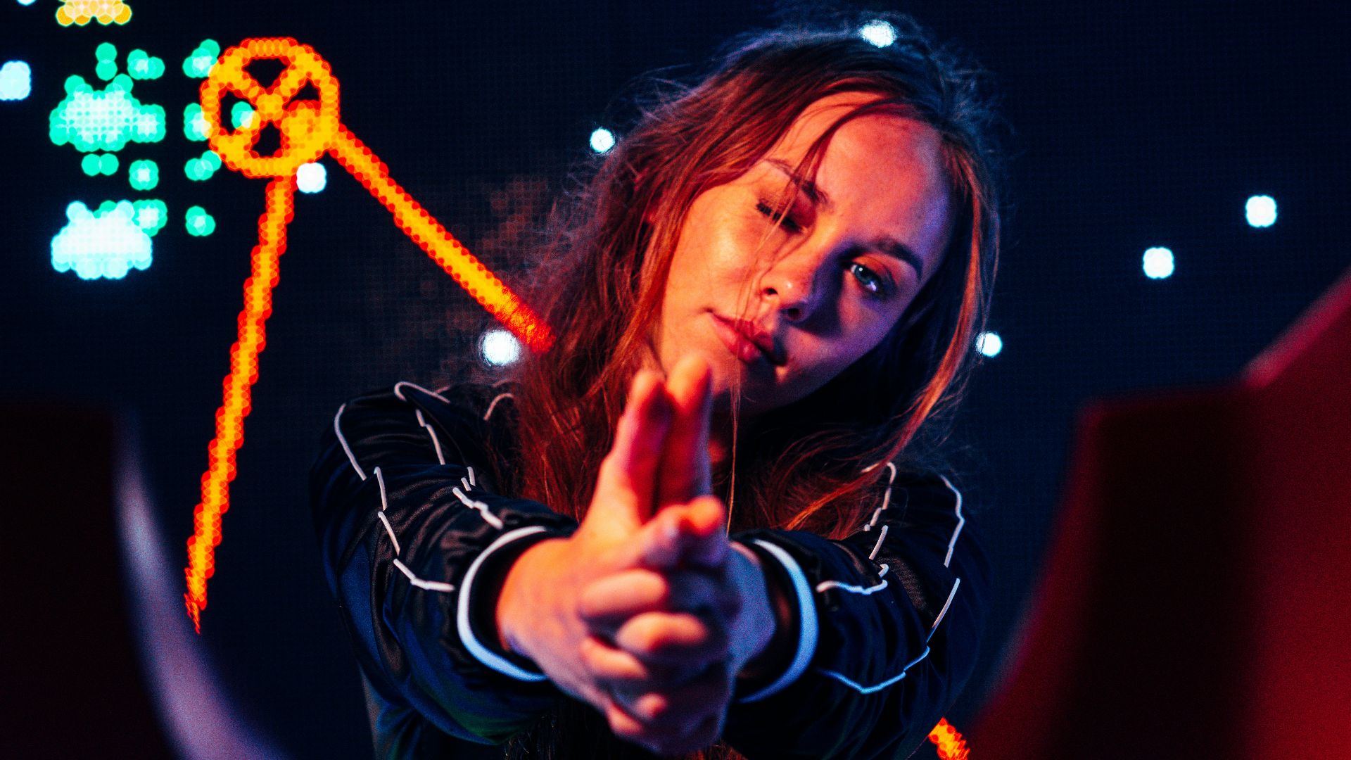 woman in black jacket making gun sign