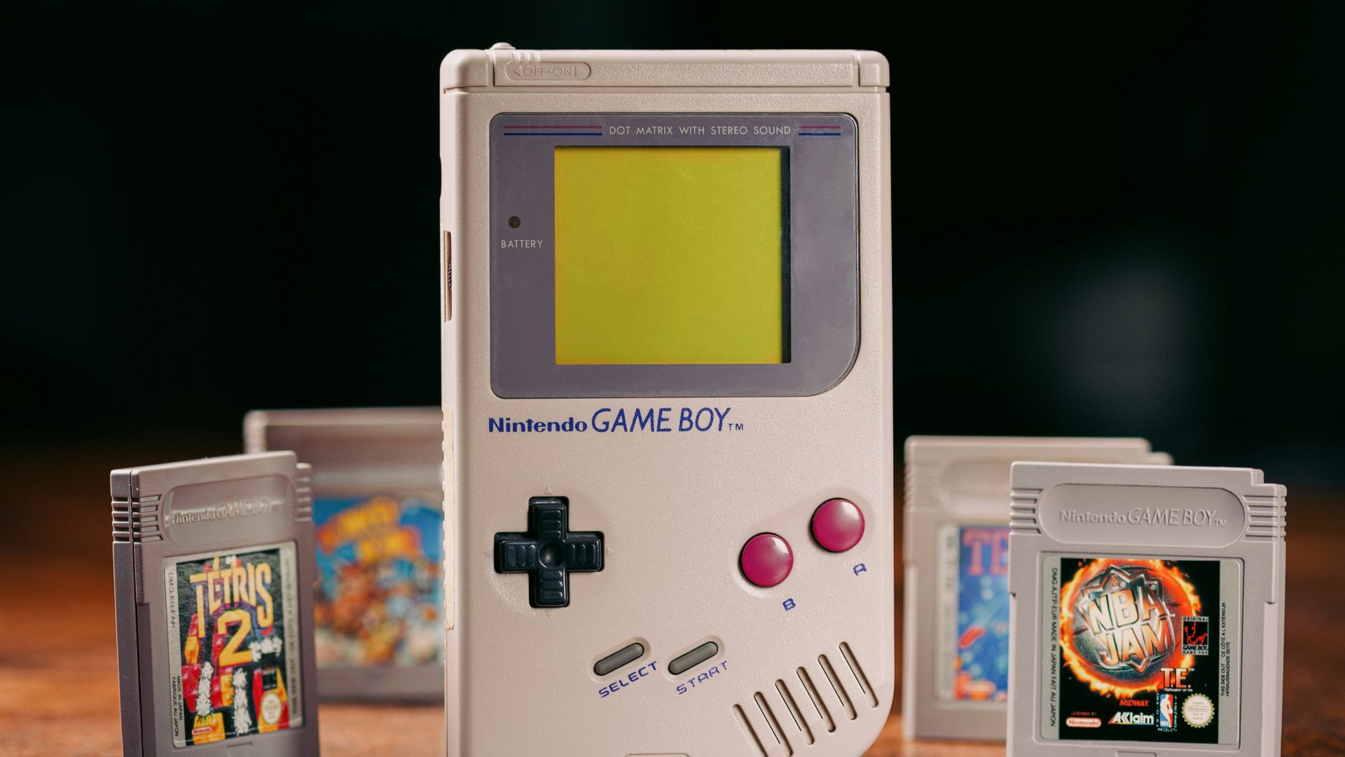 a nintendo game boy sitting on top of a wooden table