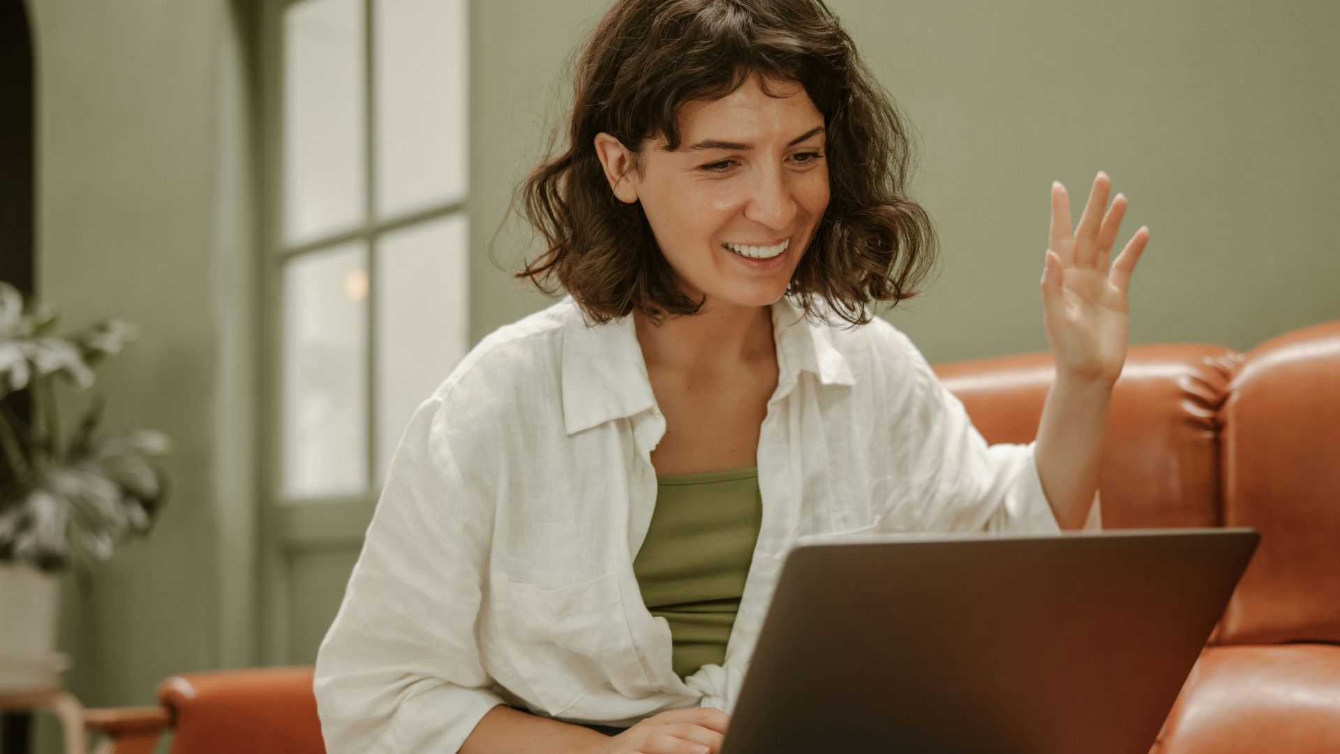 a woman sitting on a couch using a laptop computer