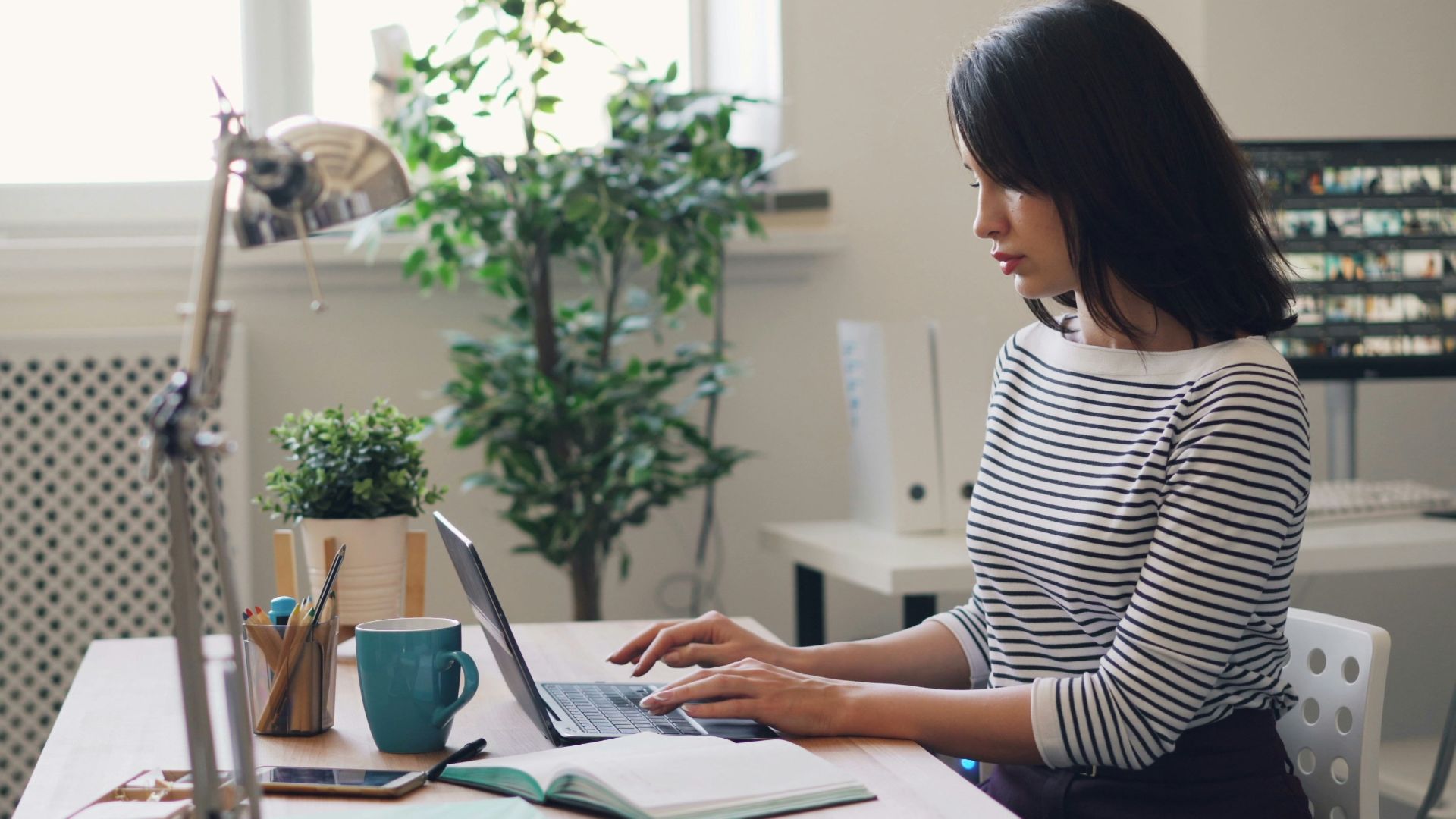 a woman sitting at a desk using a laptop computer