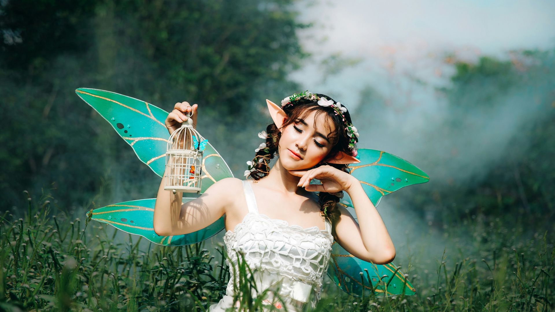 woman in white dress wearing green fairy wings
