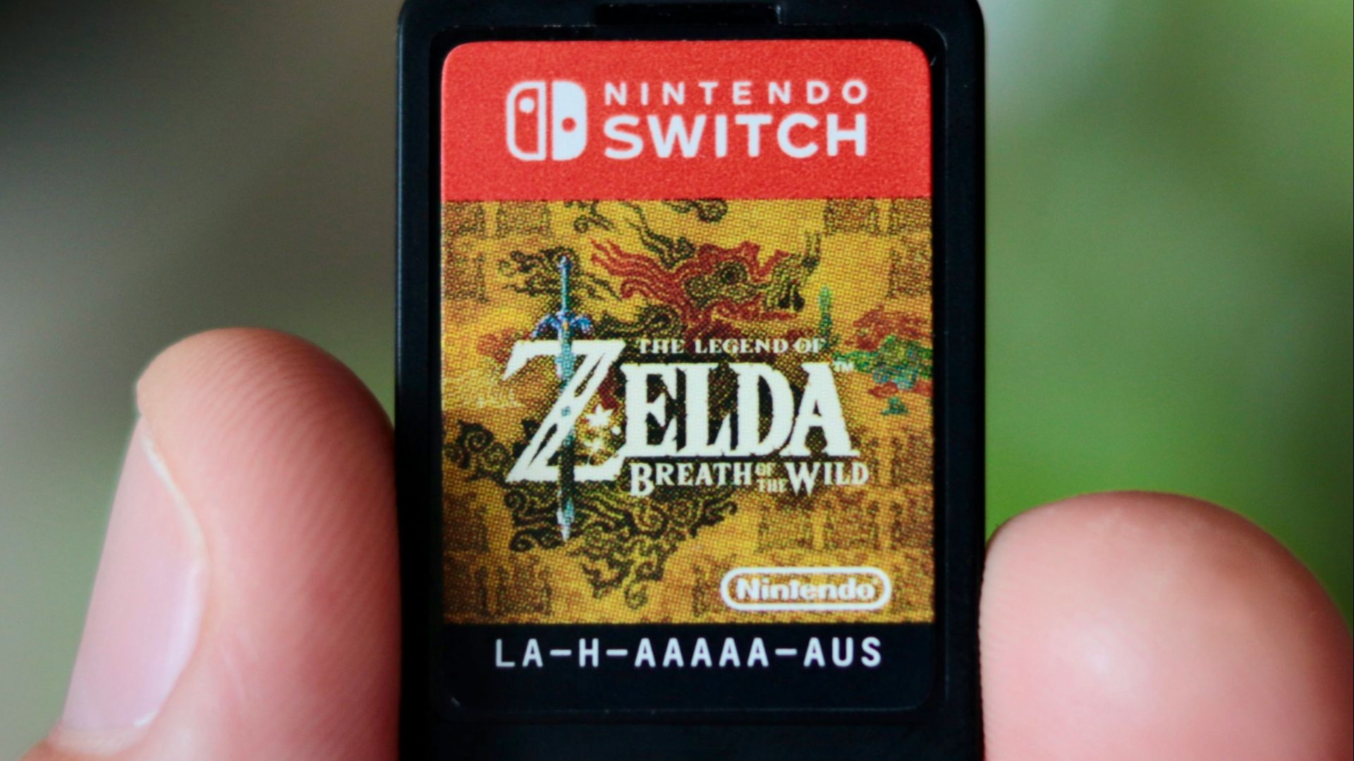 a hand holding a nintendo wii game card