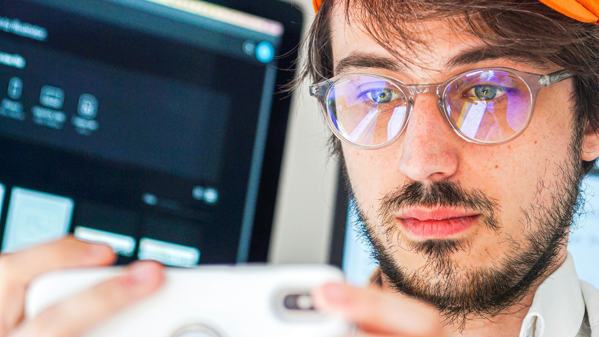 man in orange cap and black framed eyeglasses
