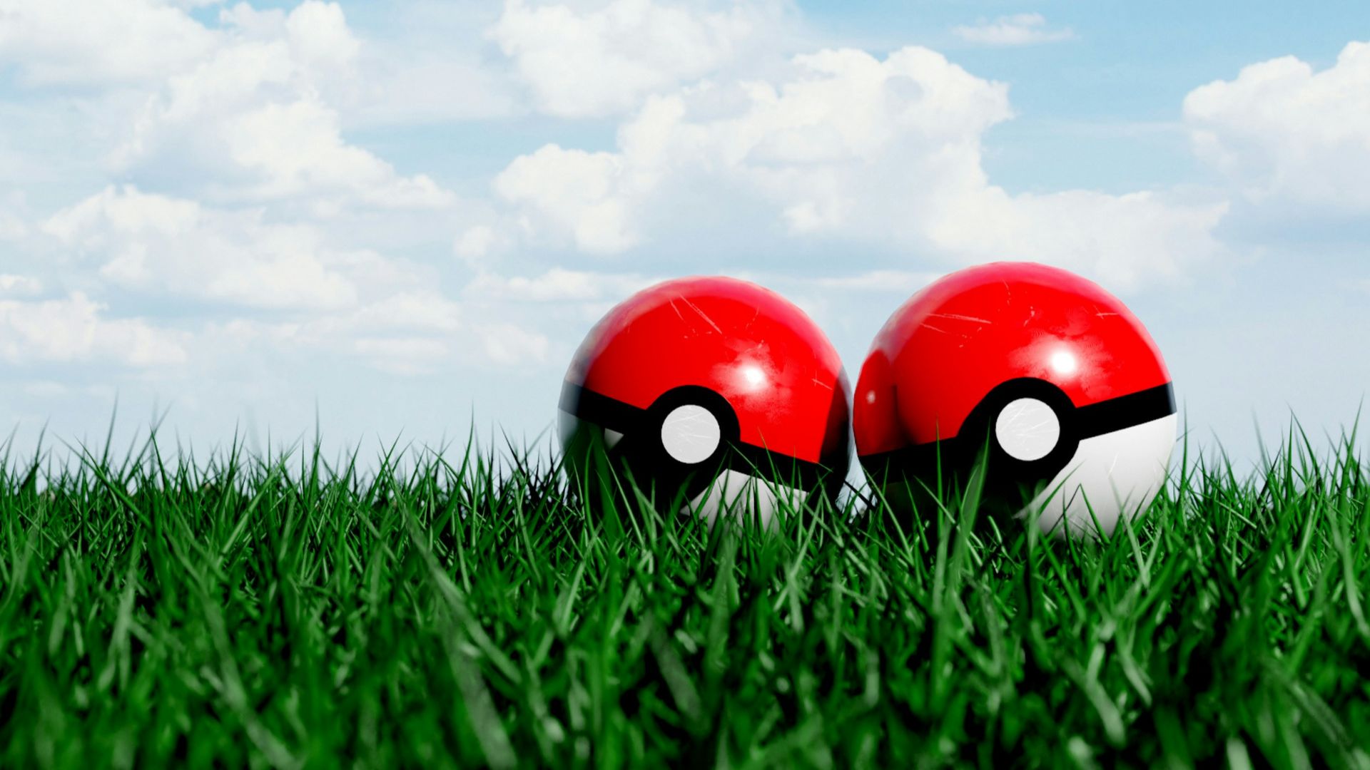 two red and white balls sitting in the grass