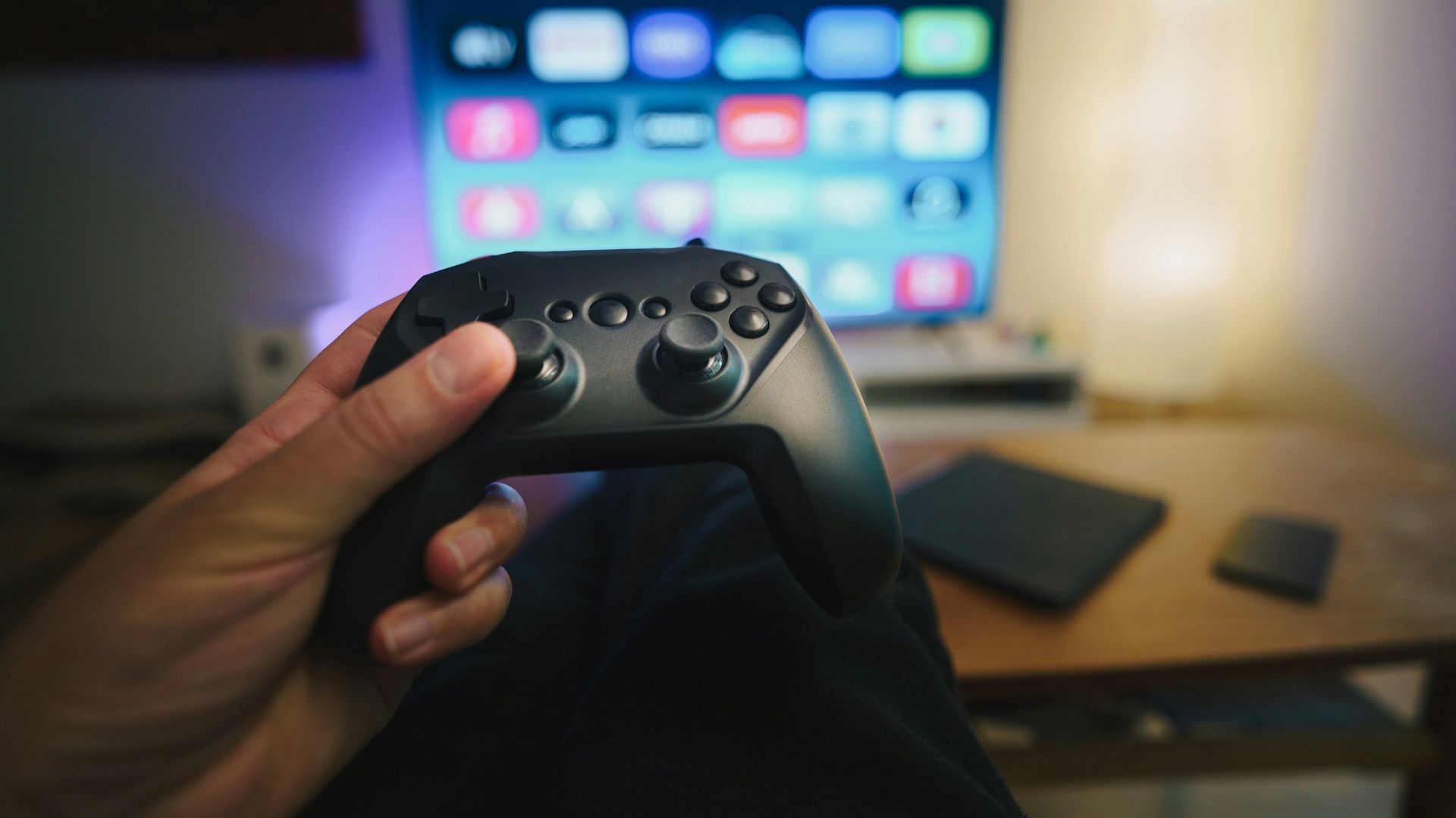 A person holding a video game controller in front of a computer