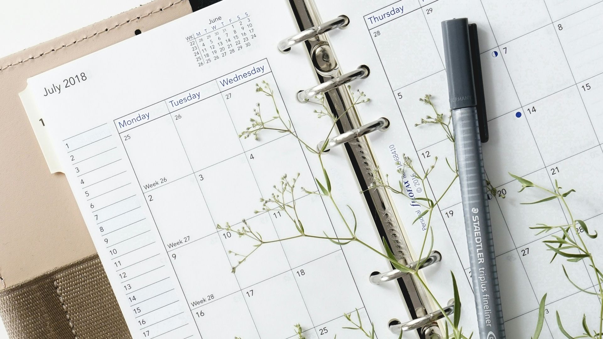 grey and black pen on calendar book