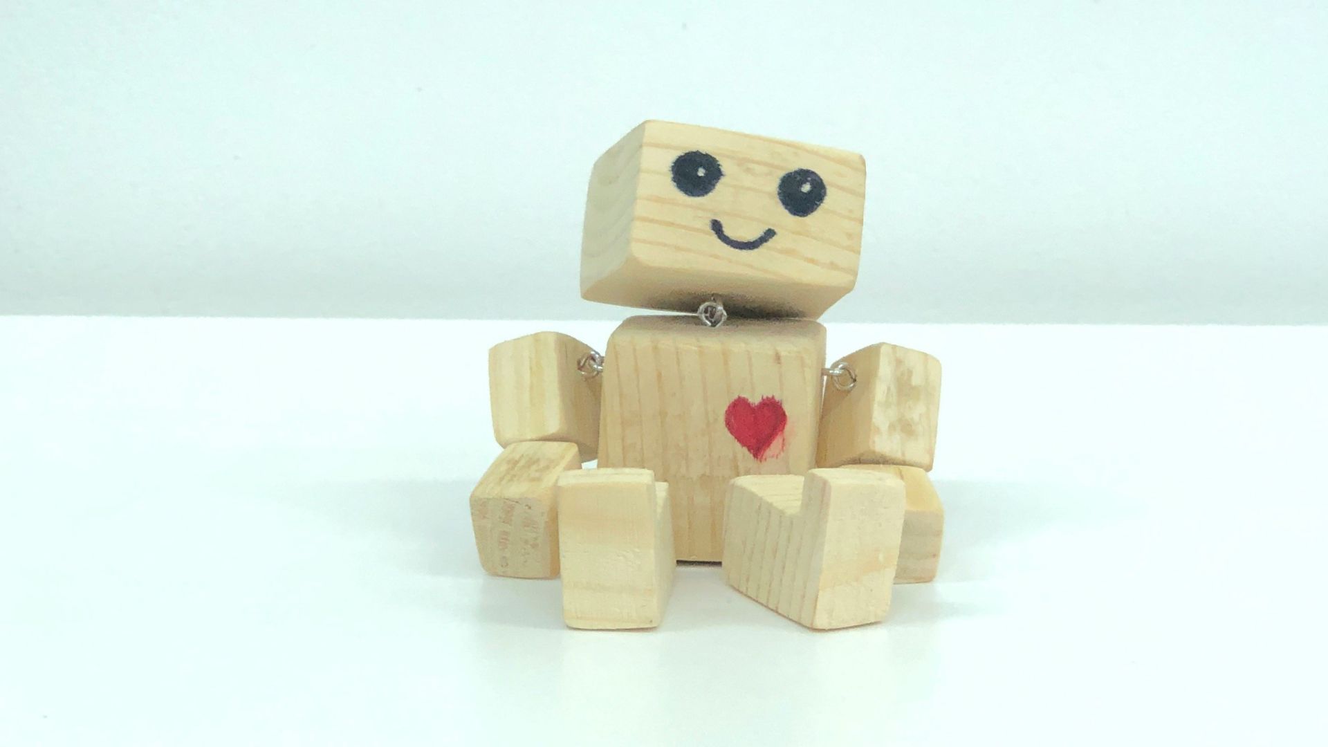 brown wooden robot toy on white surface