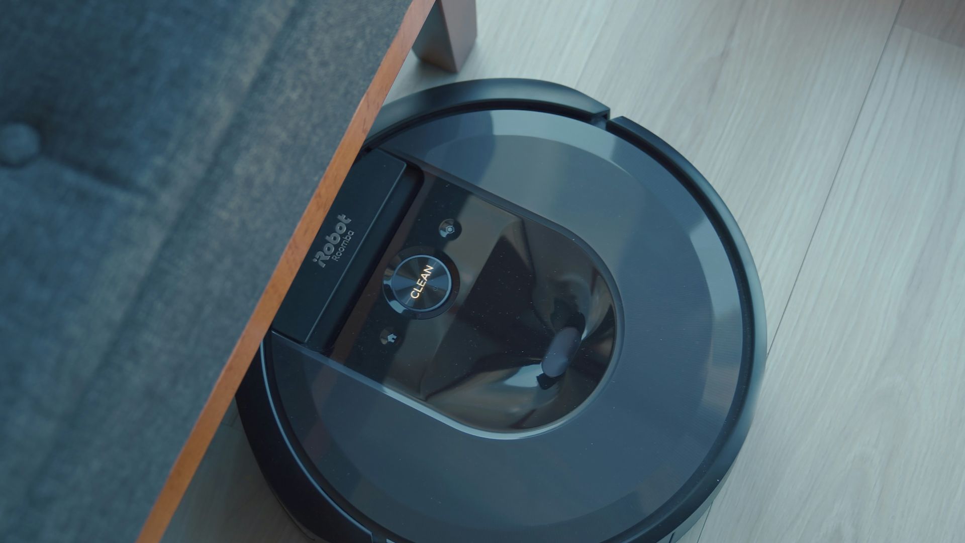 a robotic vacuum is on the floor next to a couch
