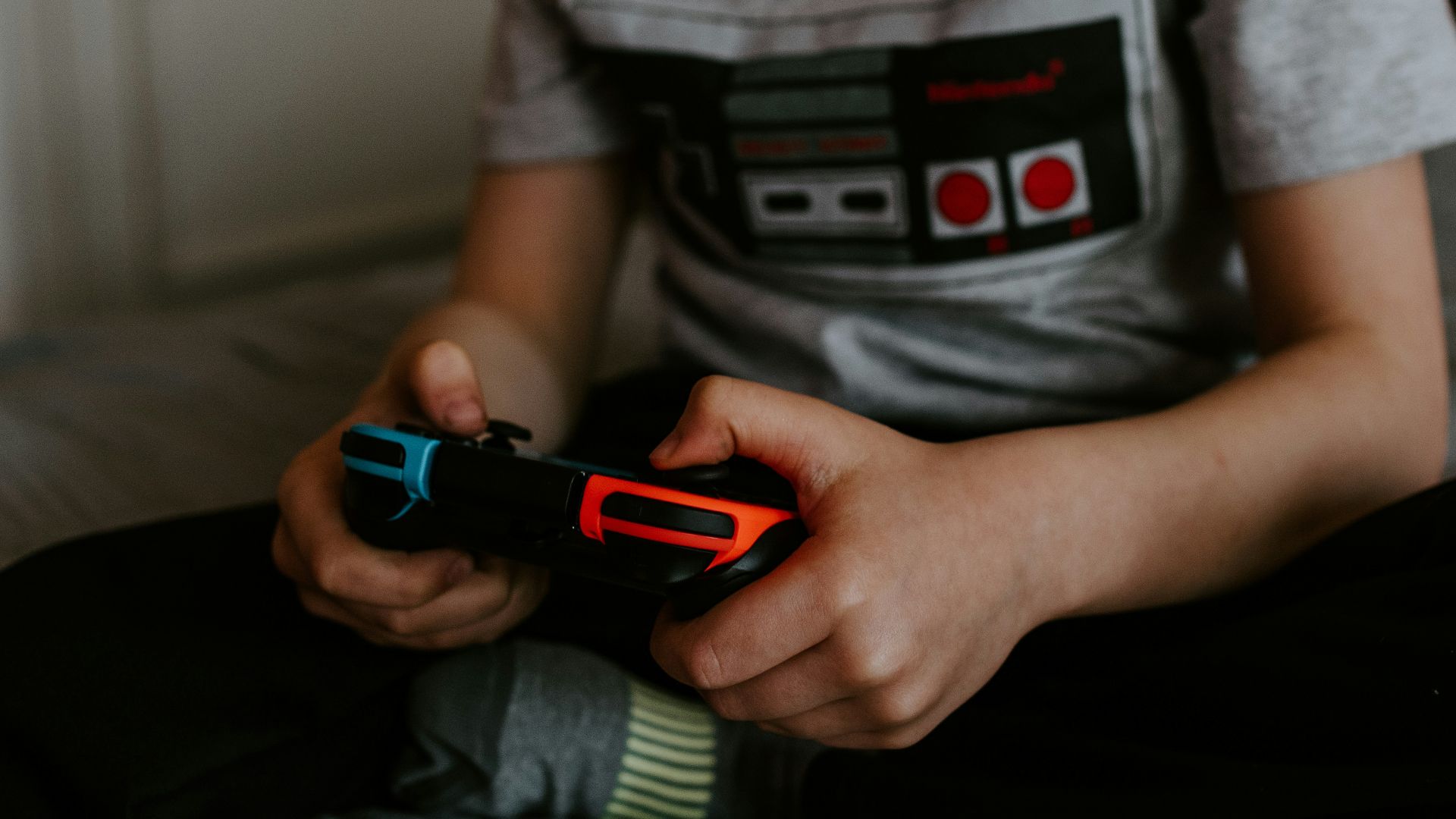kid sitting on gray bed while playing
