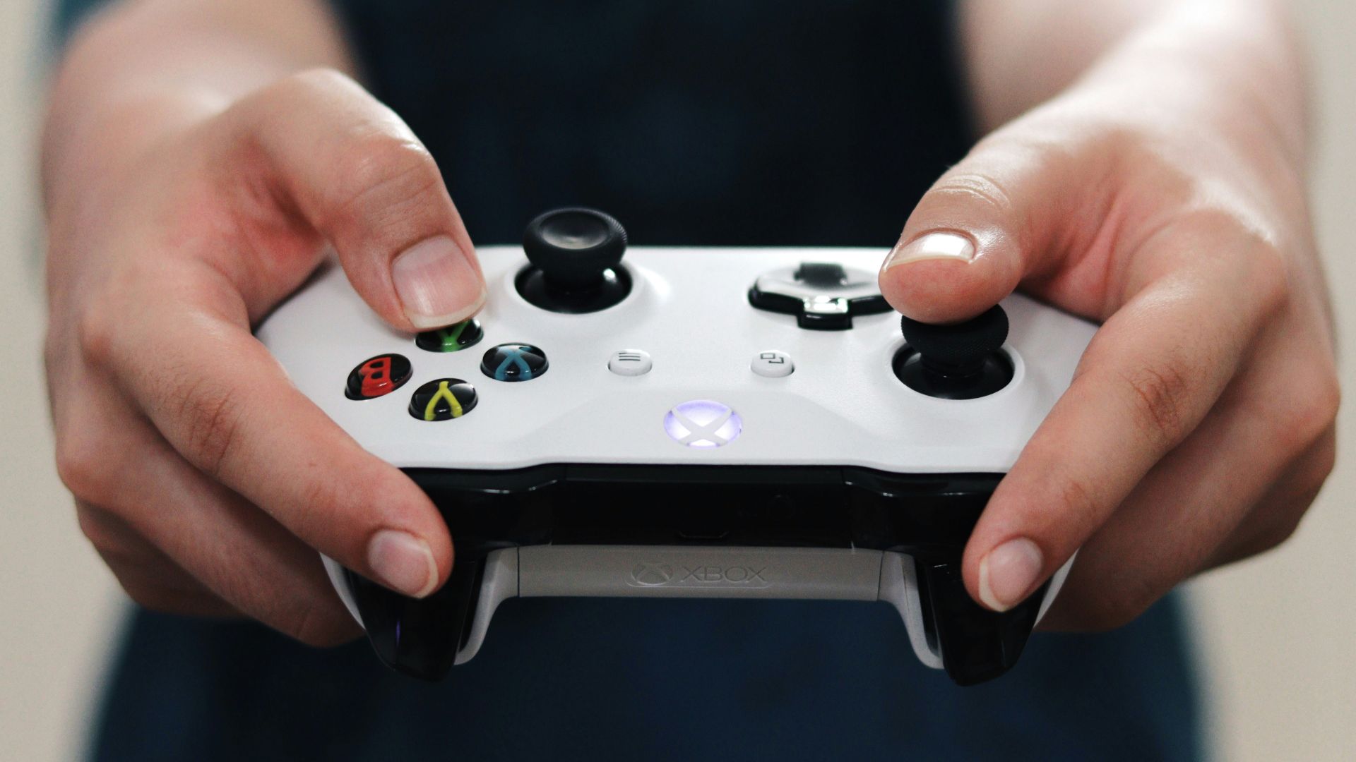 person holding white and black xbox one game controller