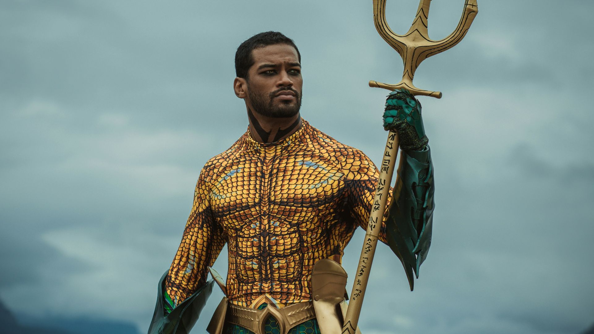 a man dressed as a mermaid holding a spear