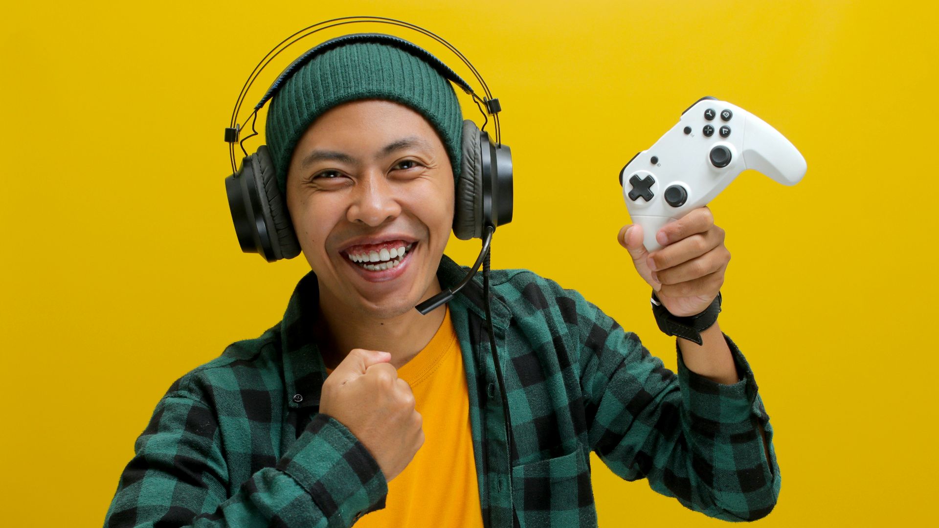 A man wearing headphones and holding a video game controller