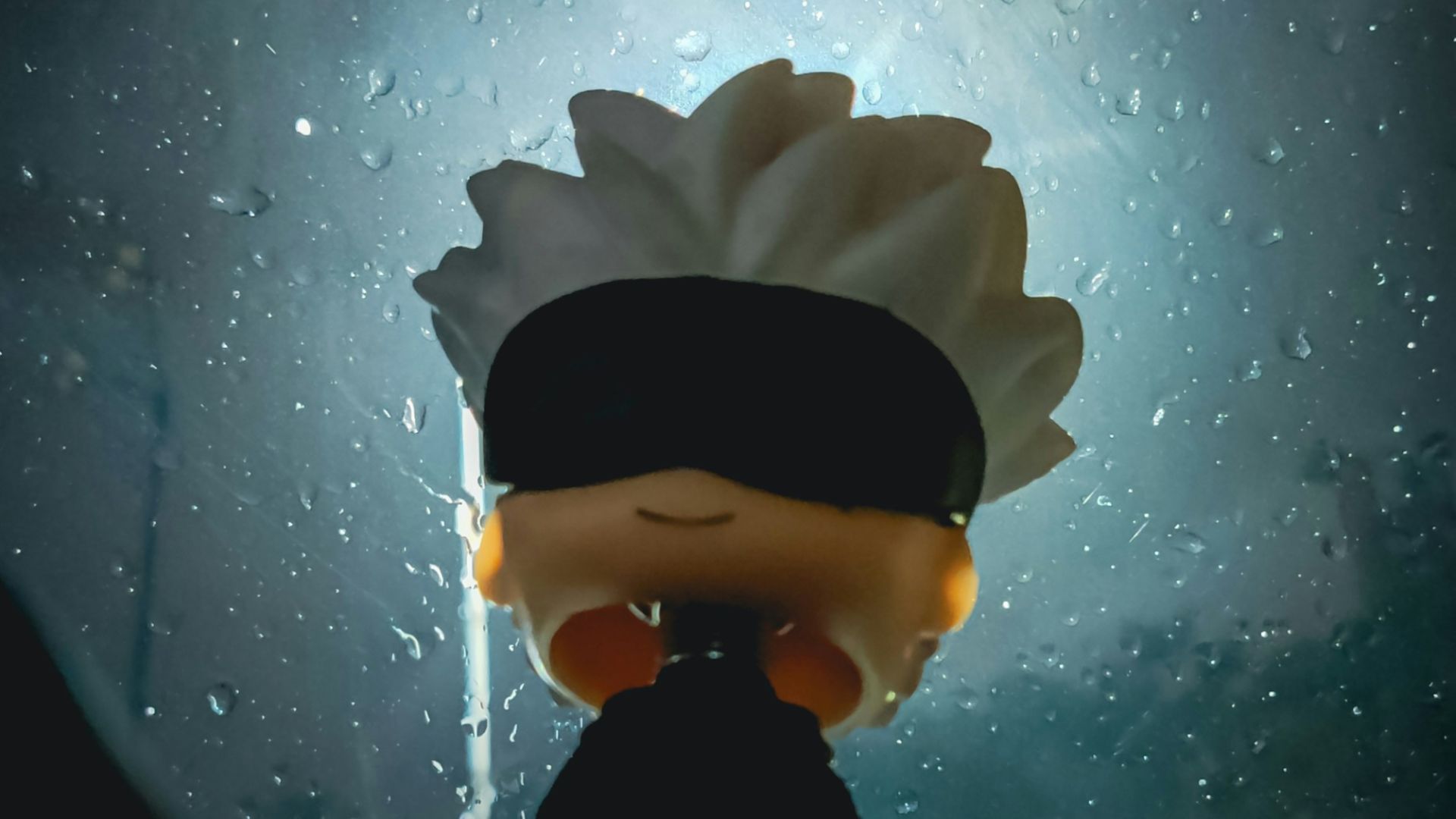 A person with a blindfolded head standing in front of a window