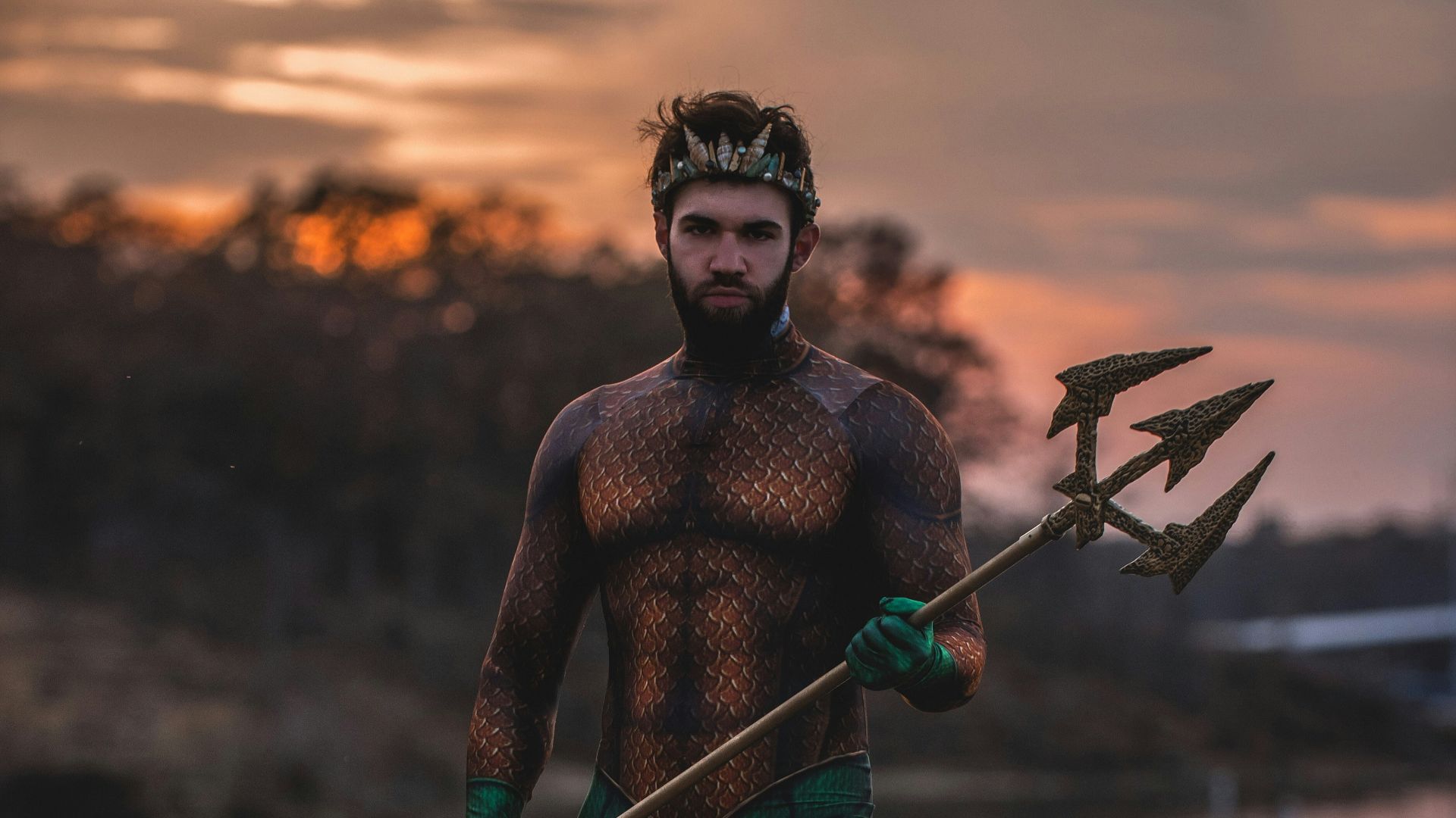 man wearing Poseidon costume standing on rock
