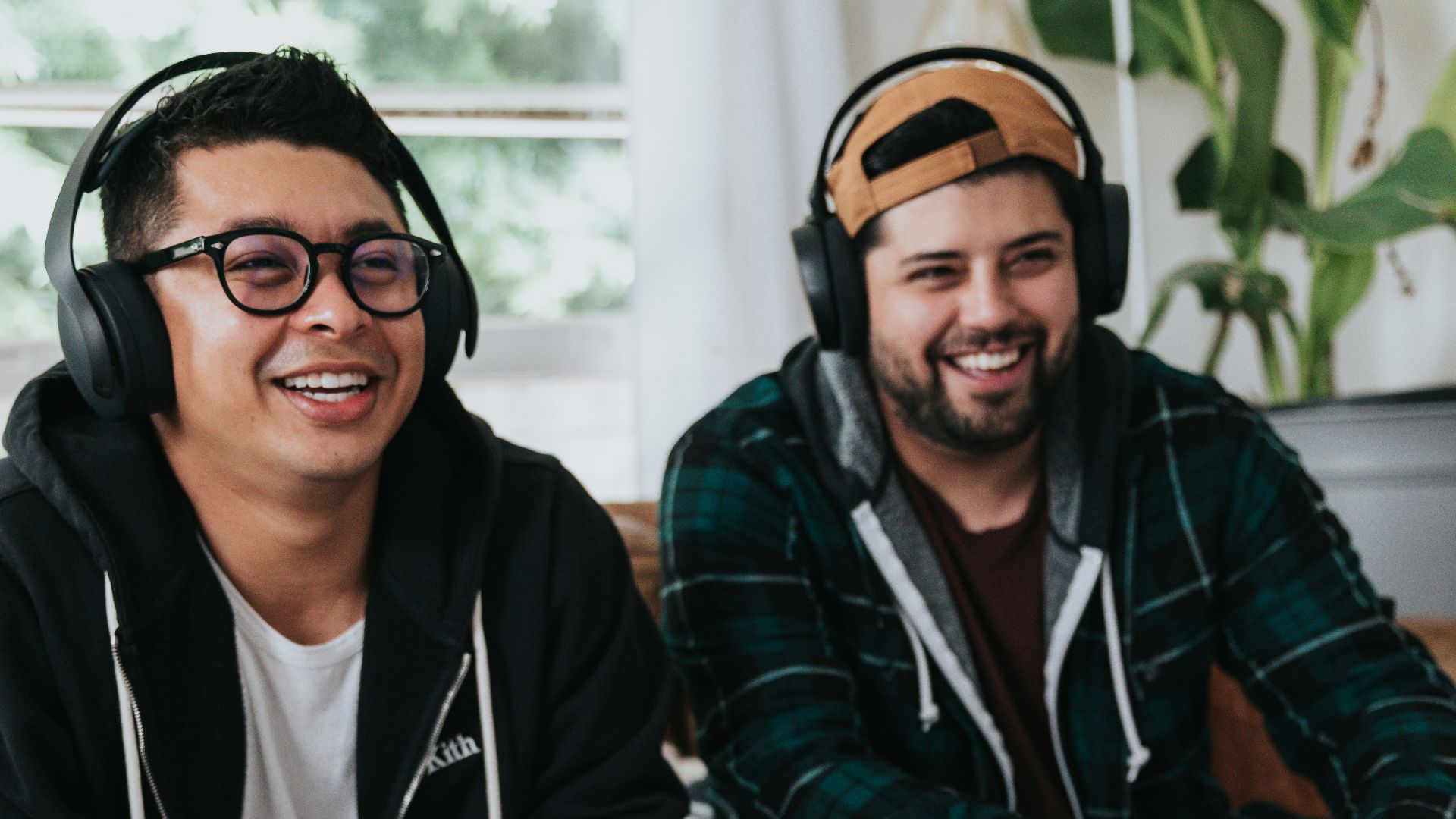 a couple of men sitting at a table with game controllers