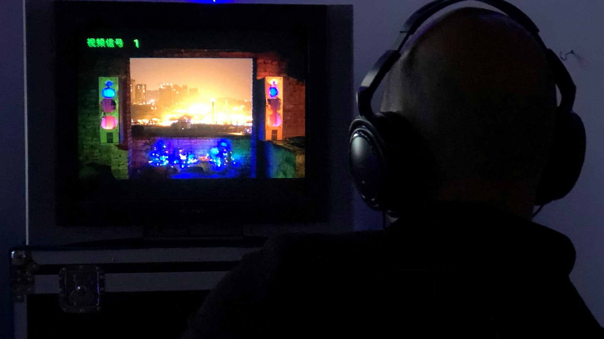 a man sitting in front of a tv with headphones on