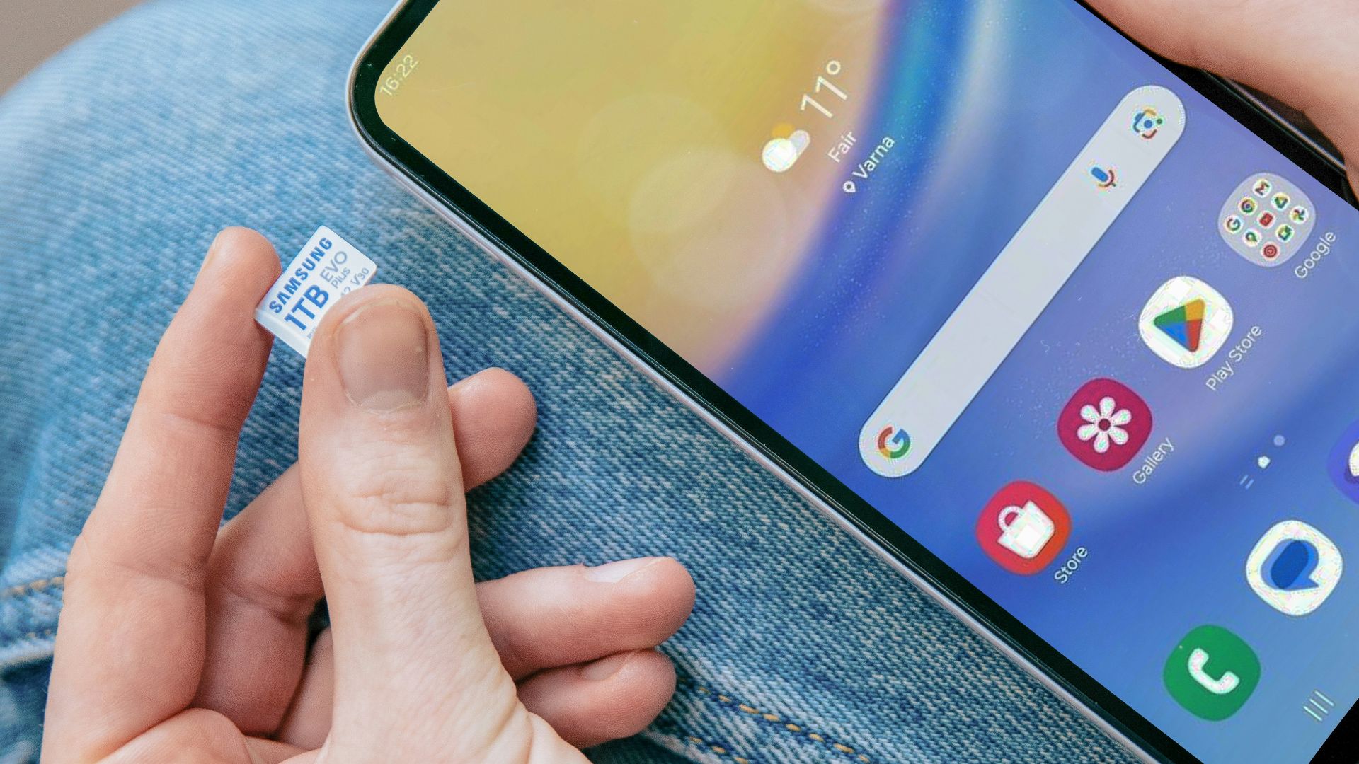 A person sitting on the ground holding a cell phone