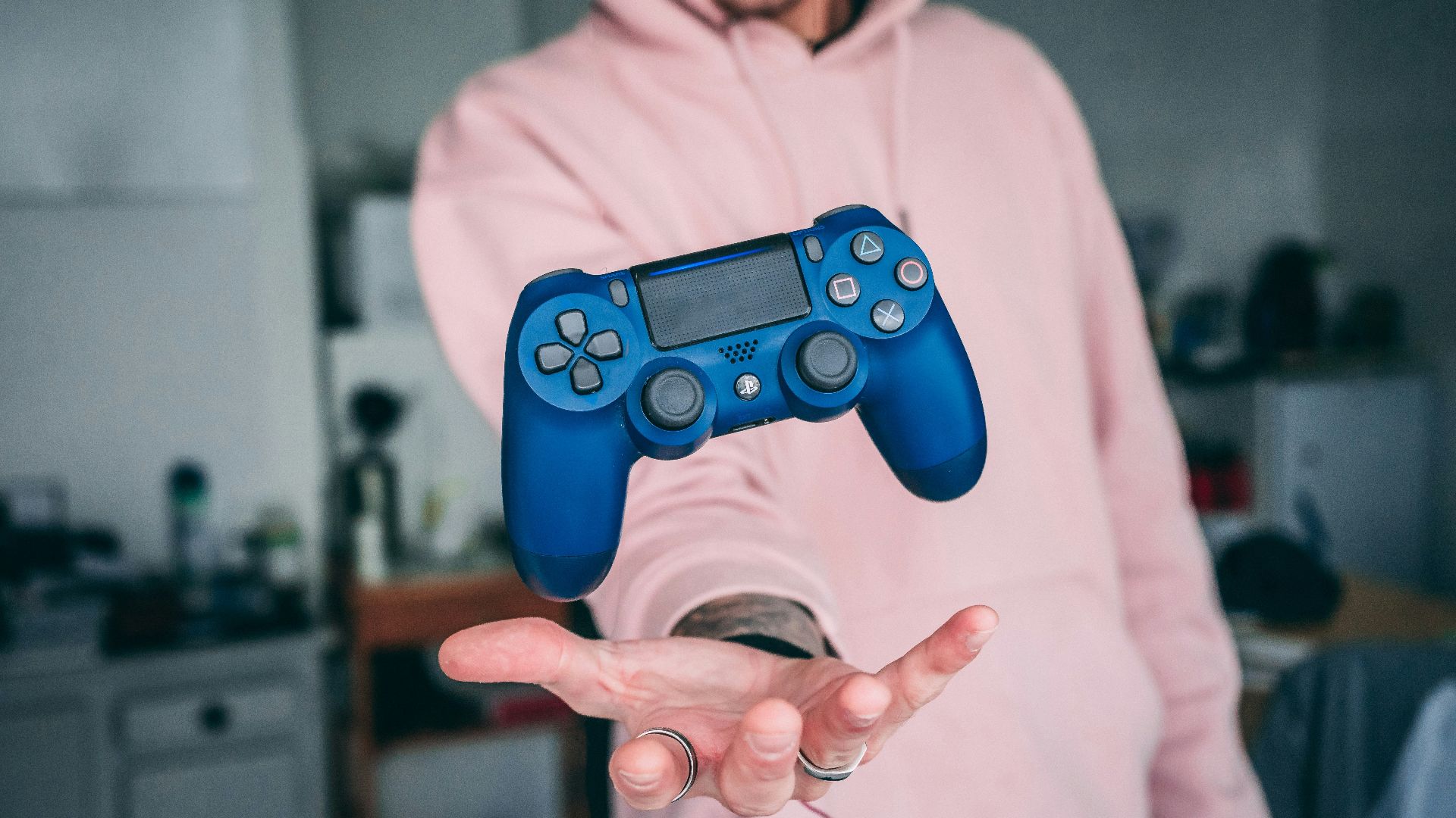 person holding blue Sony PS4 Dualshock 4 c
