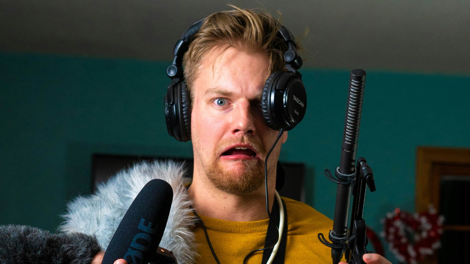 man in yellow long sleeve shirt holding microphone
