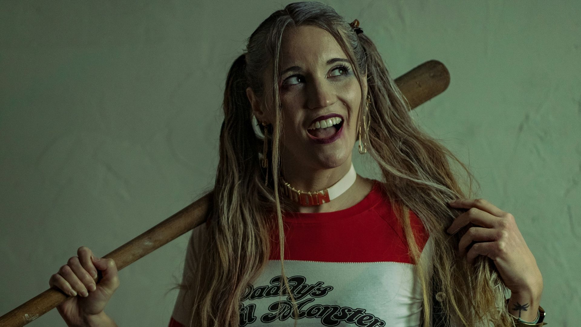 woman in white and red adidas crew neck t-shirt holding brown wooden baseball bat