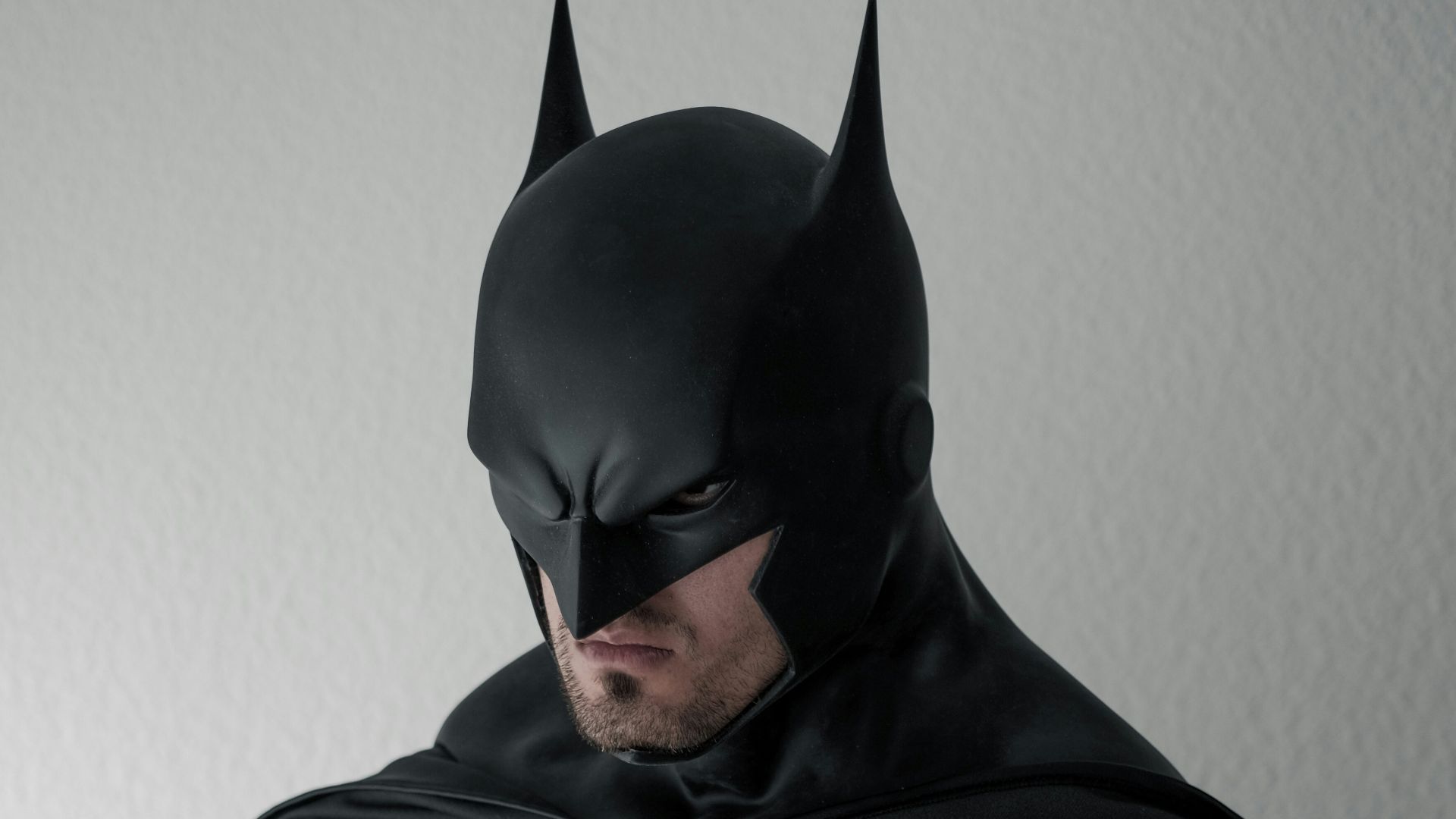 man in black and gray stripe hoodie sitting on brown wooden chair