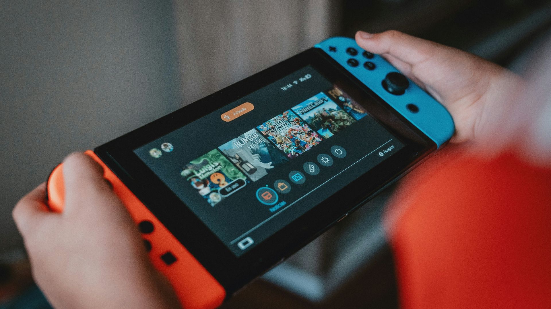 person holding black and orange nintendo switch