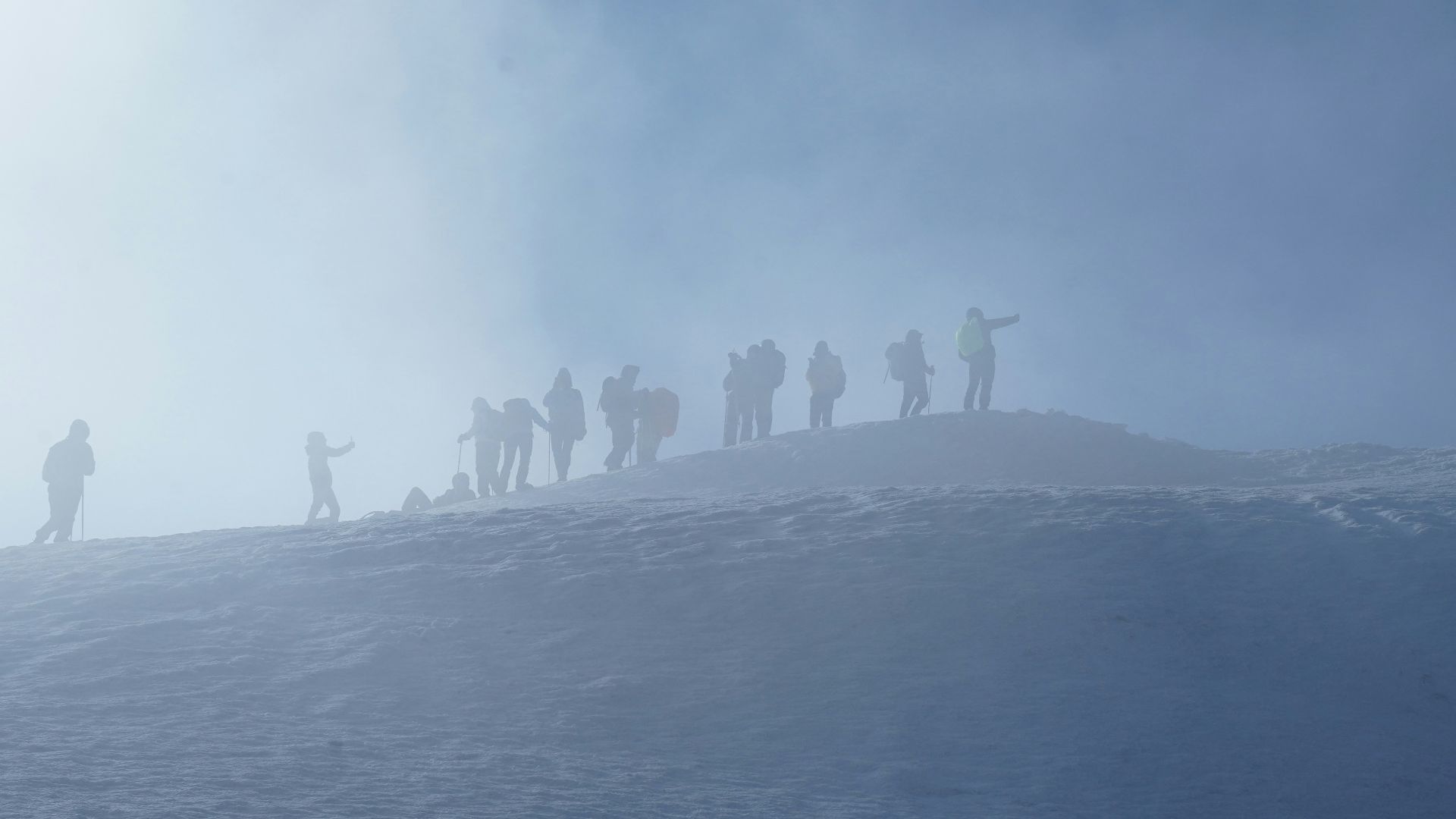 a group of people standing on top of a snow covered slope