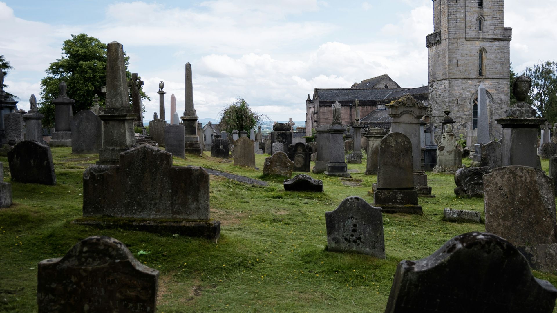 a cemetery with a tall tower in the background