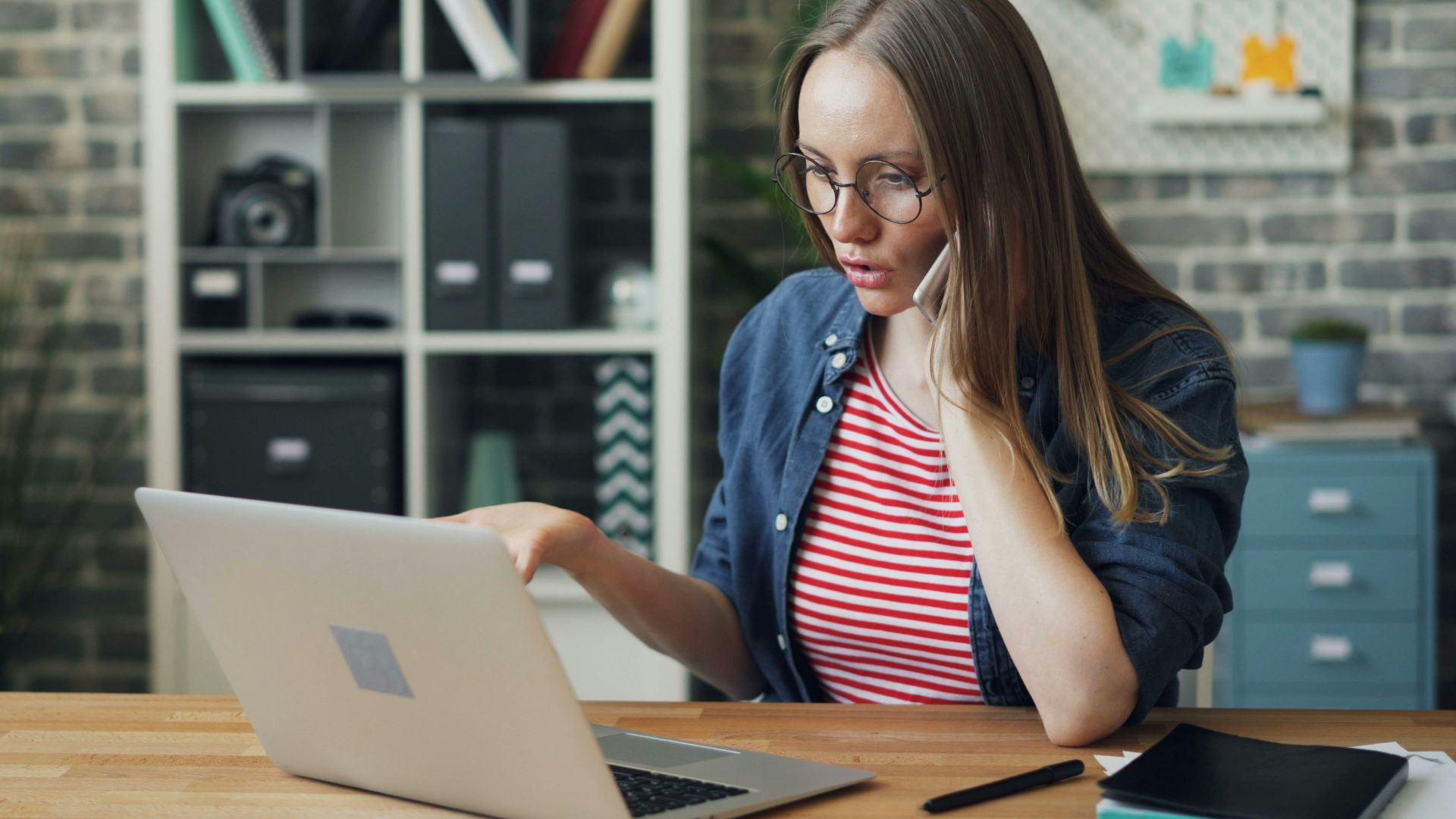 a woman sitting at a table using a laptop computer