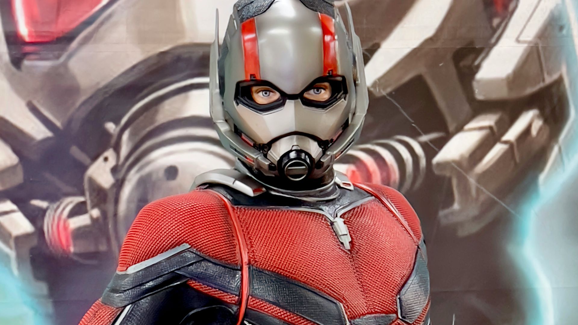 a man in a red and black suit standing next to a giant robot