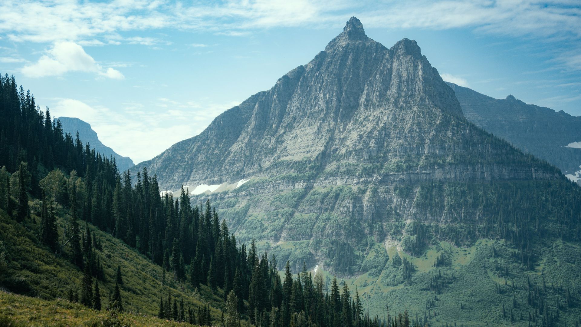 A view of a mountain range with trees and mountains in the background