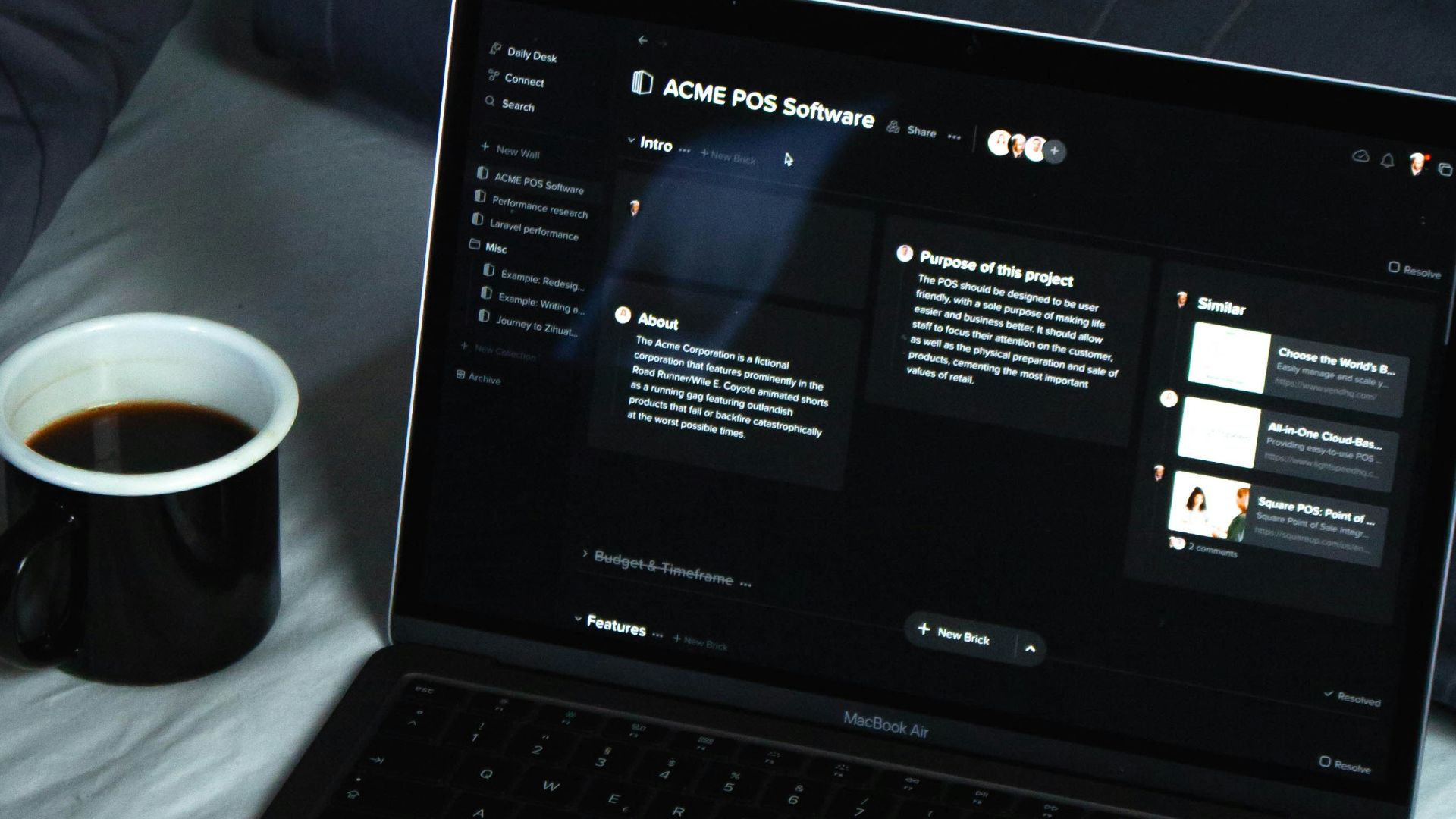 black laptop computer on white bed