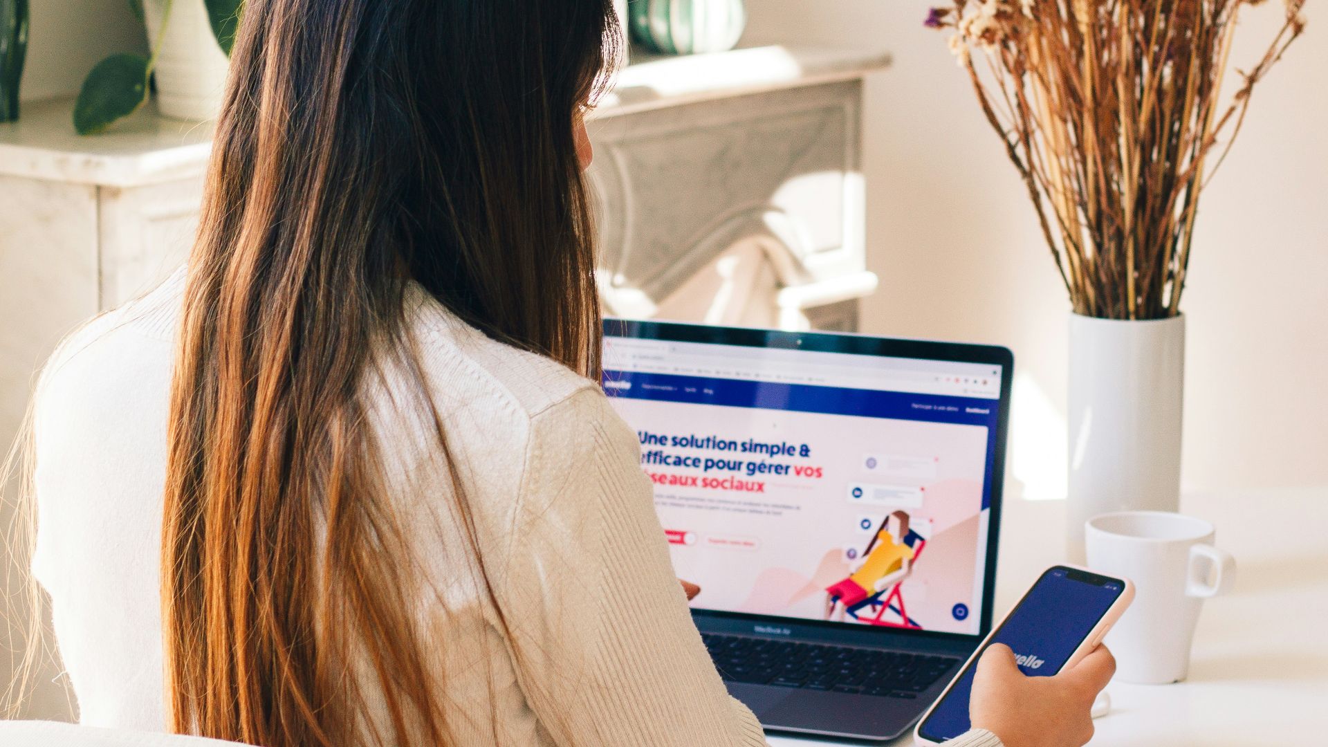 a woman sitting at a table using a laptop computer