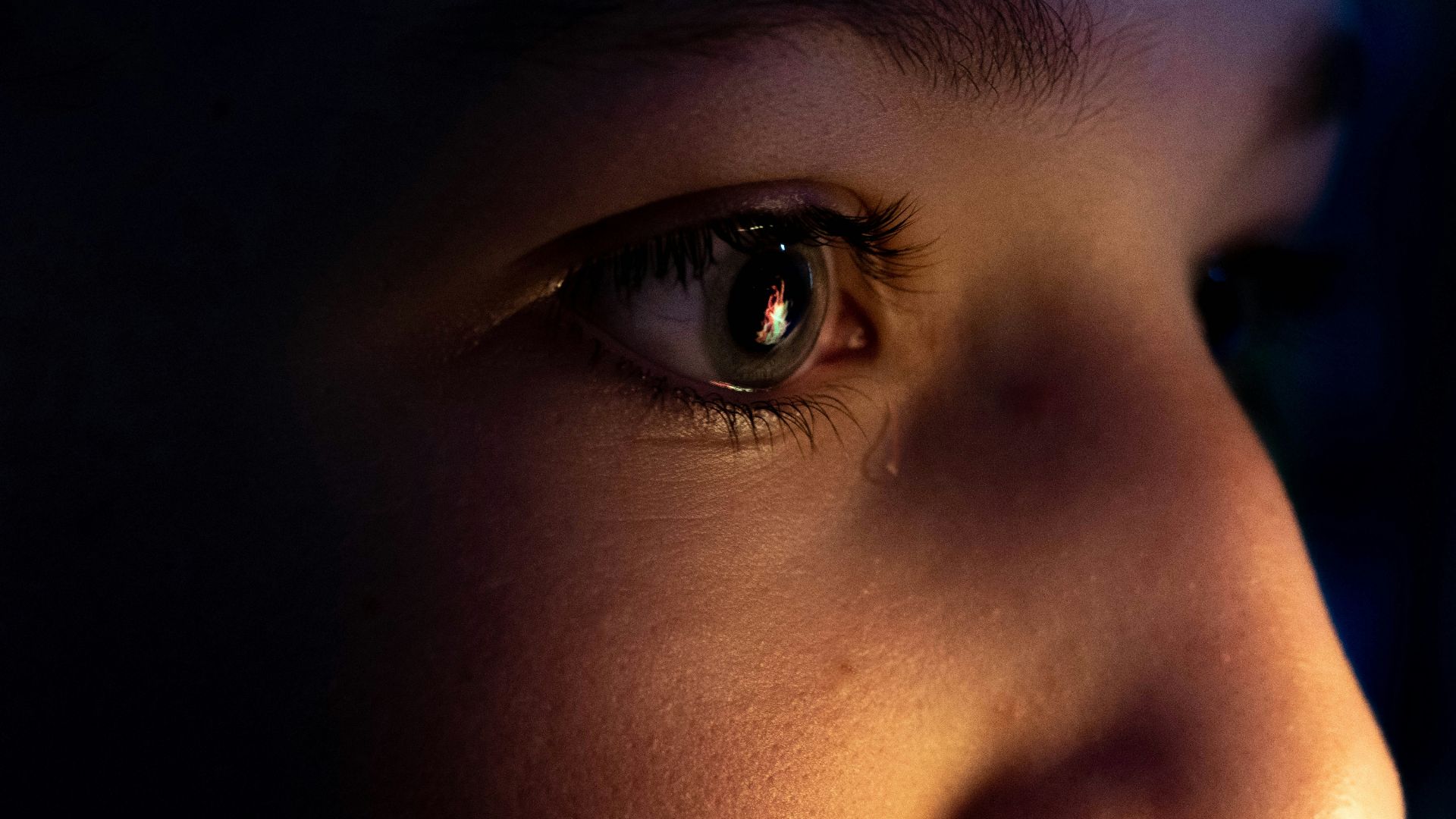 a close up of a child's face with a dark background