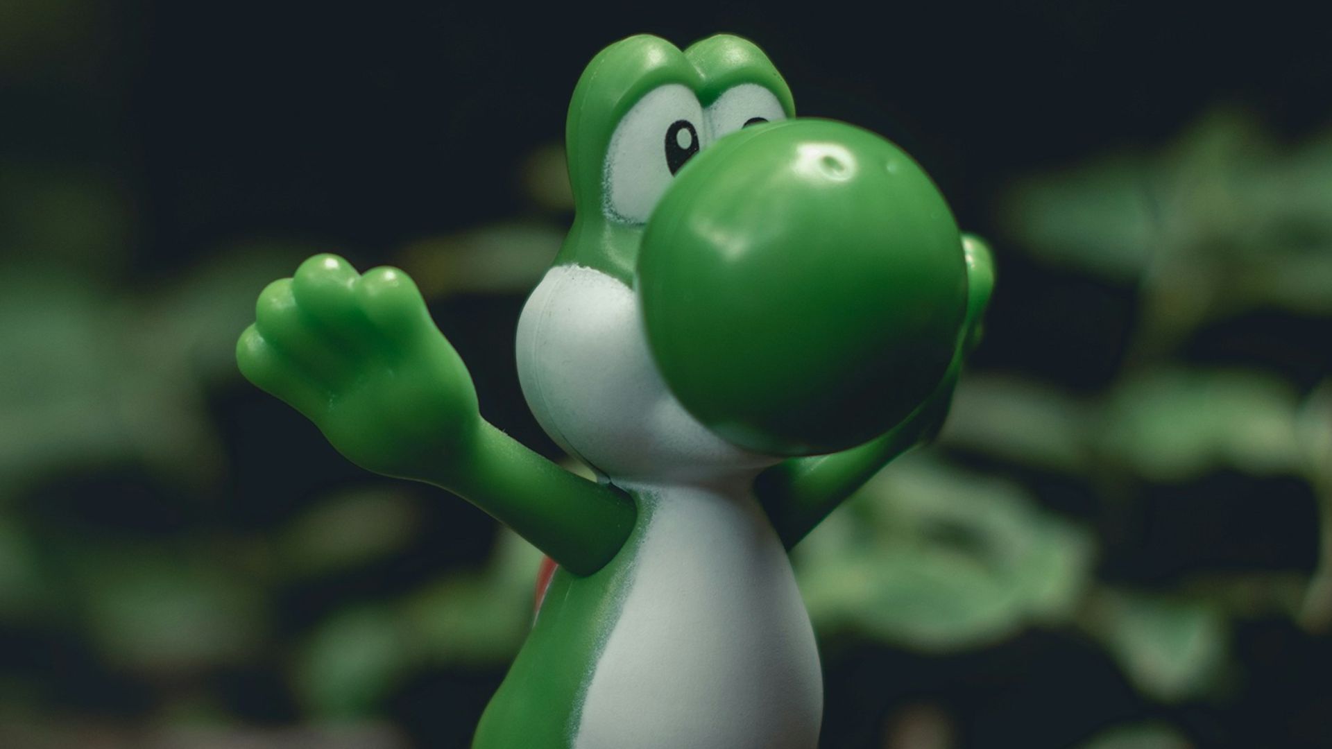 green frog figurine on black and brown surface