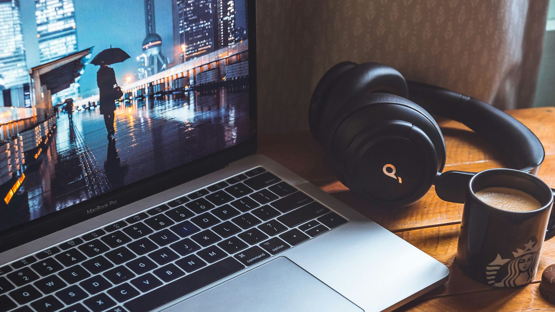 macbook pro beside black headphones