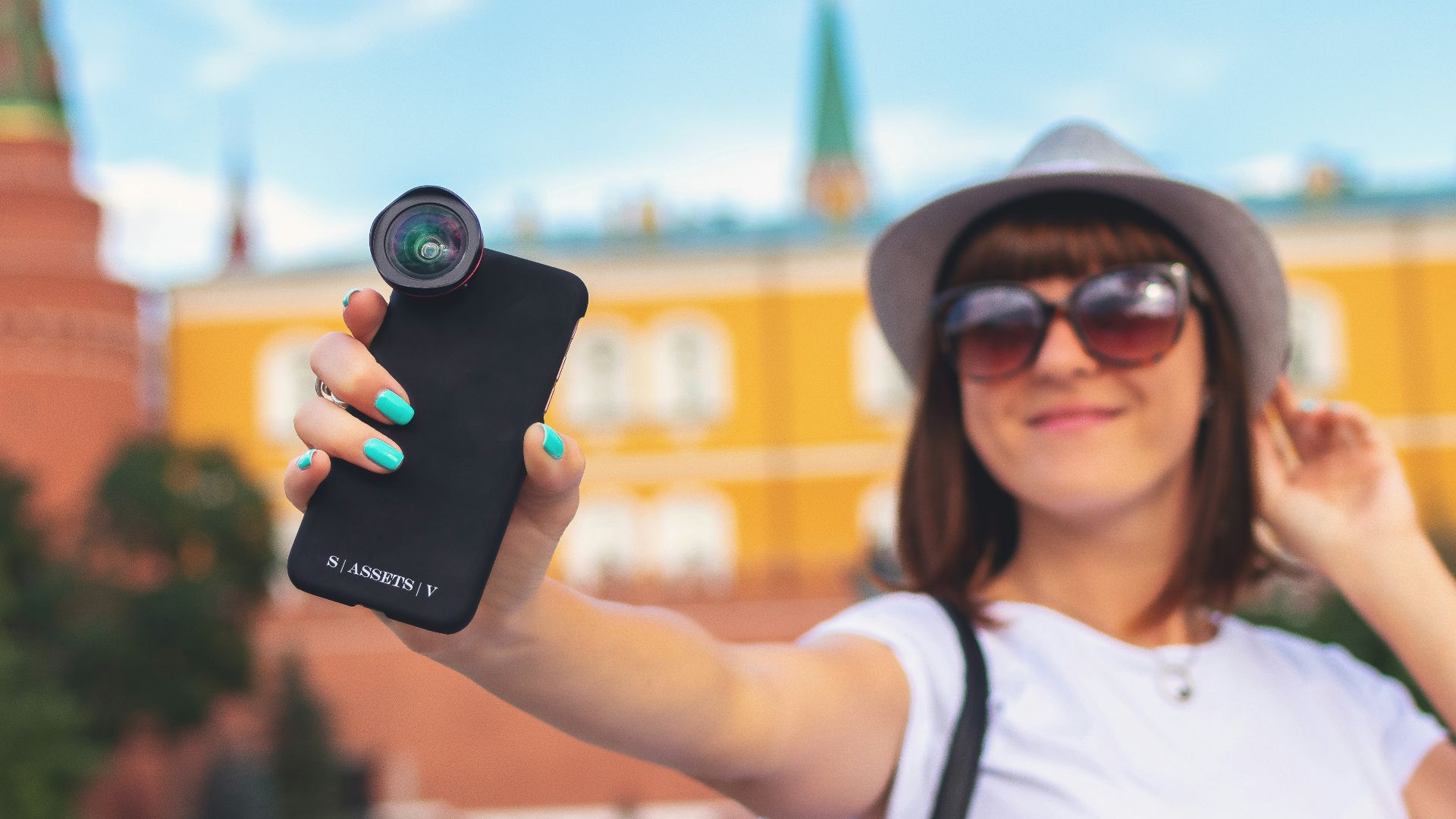 woman holding smartphone with clip lens