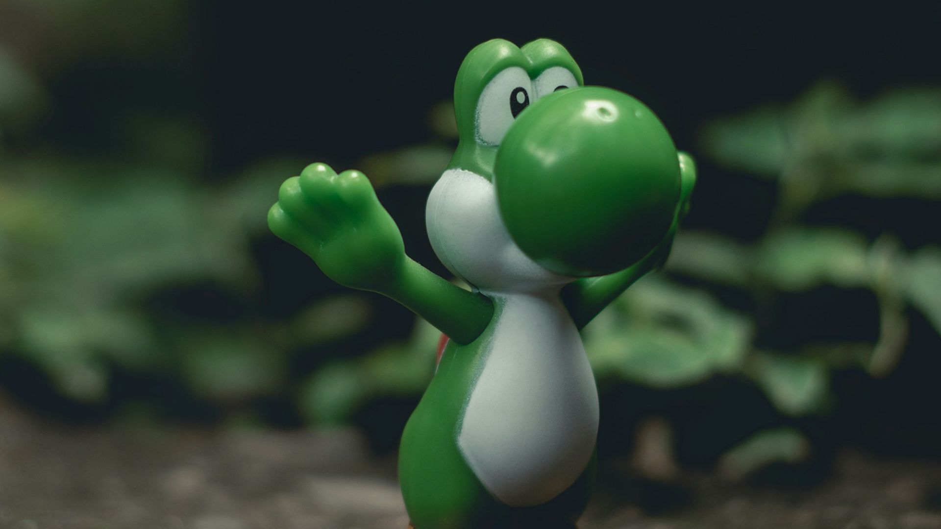 green frog figurine on black and brown surface