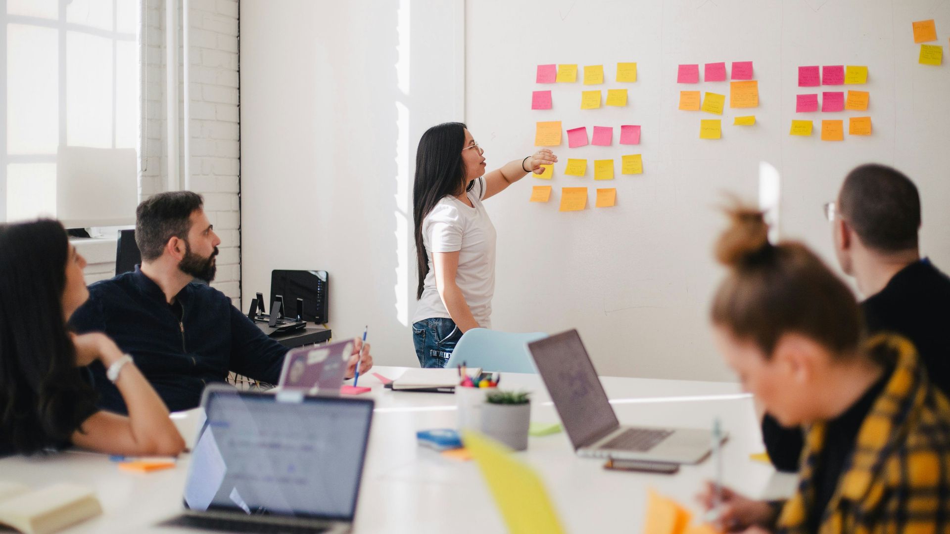 woman placing sticky notes on wall