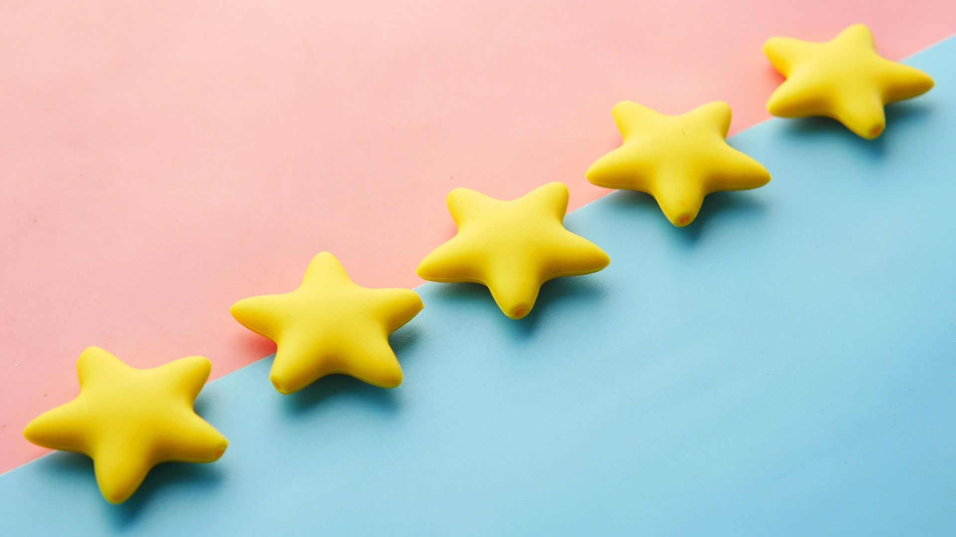 a row of yellow stars sitting on top of a blue and pink surface