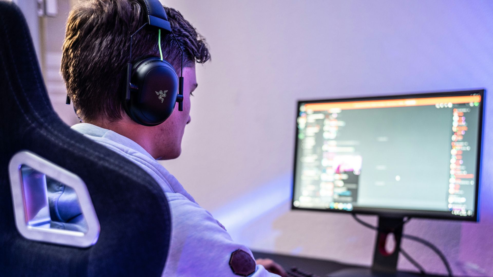 a man wearing headphones sitting in front of a computer