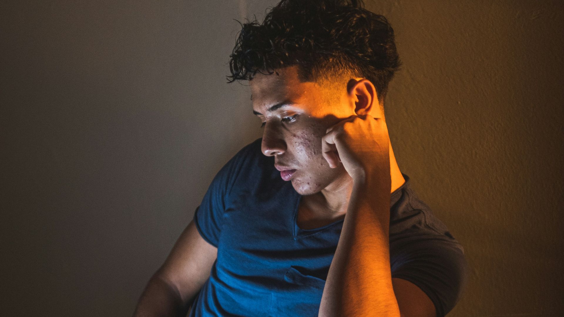 man in blue crew neck t-shirt sitting on chair