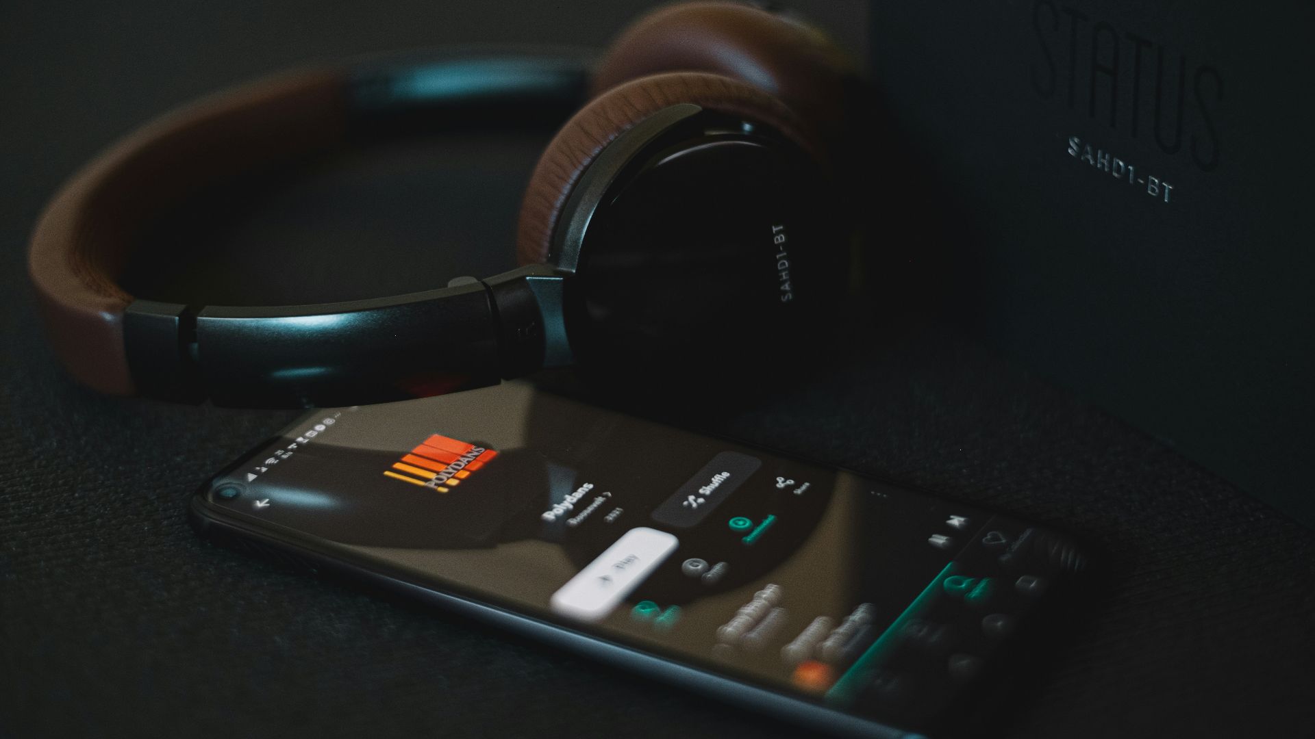 black and white remote control beside black headphones
