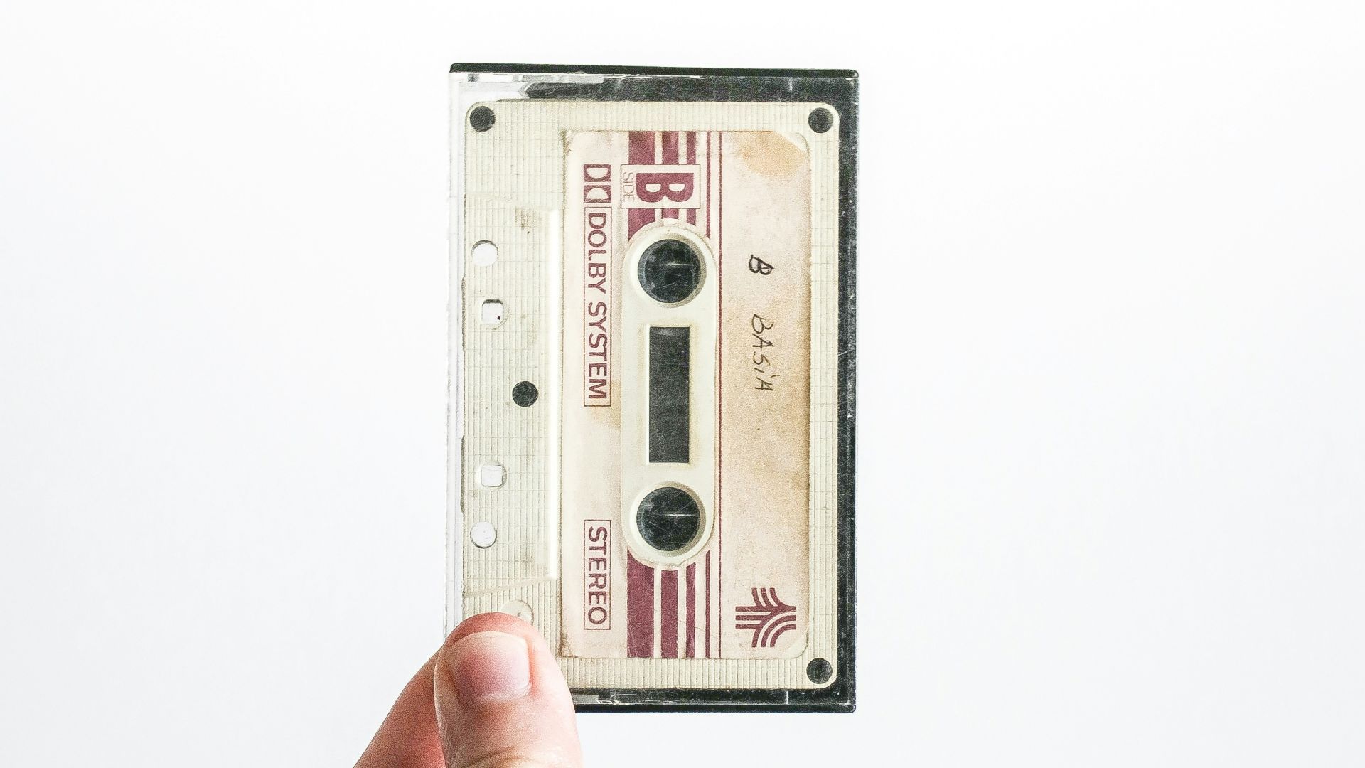 person holding brown cassette tape