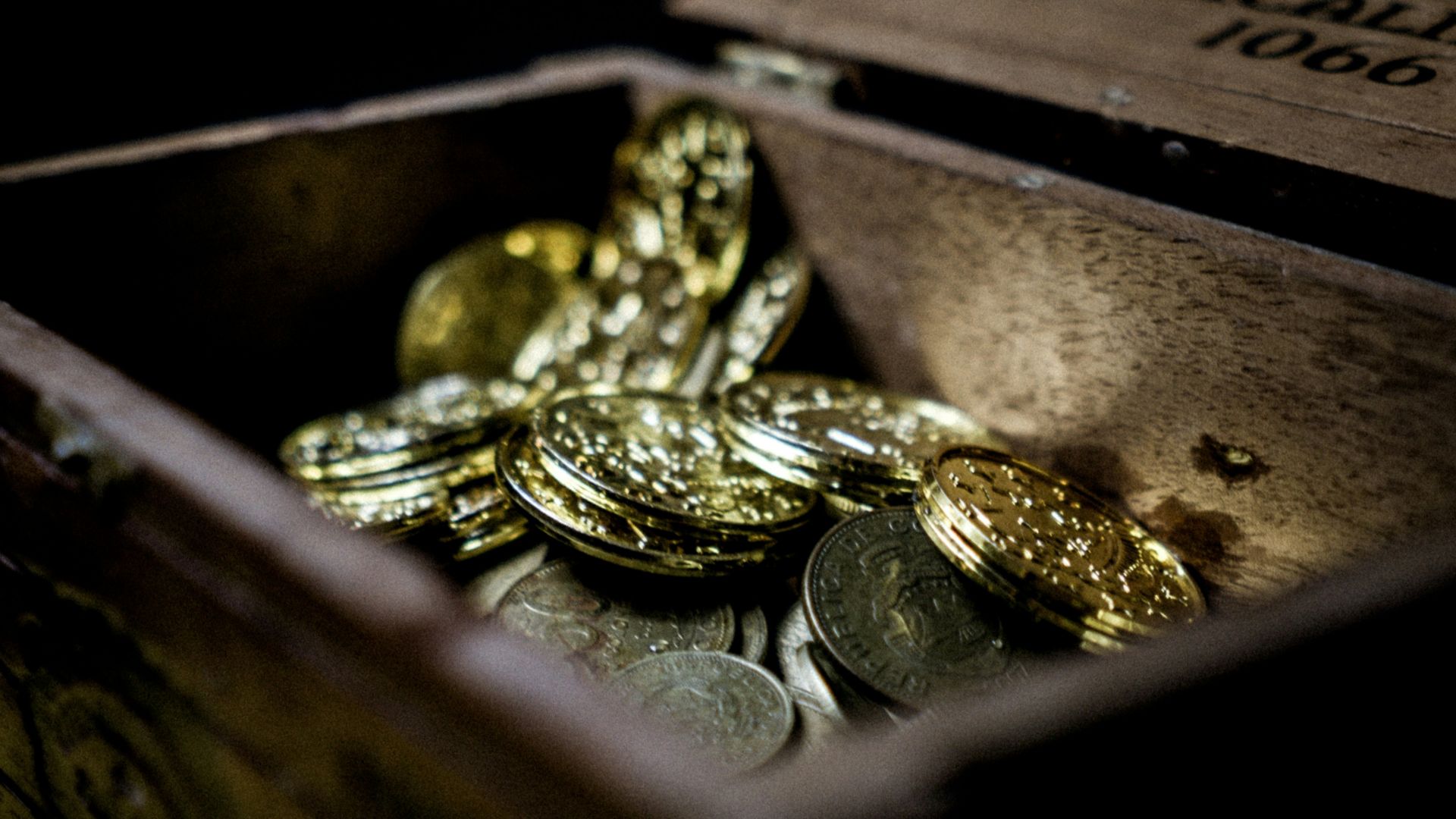 a wooden box filled with lots of coins
